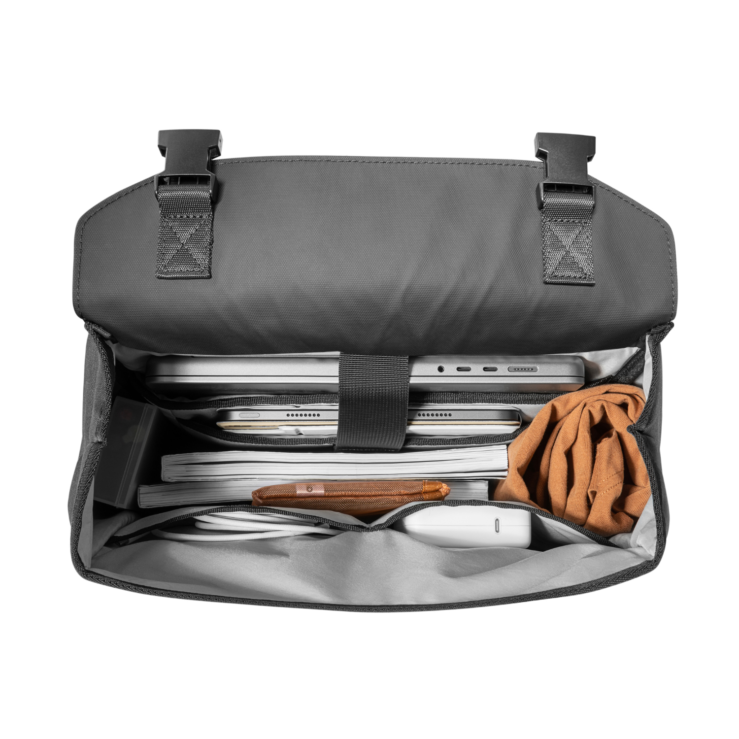 Zaino aperto pieno di oggetti: laptop, carte, portafoglio, cavo e panno. Interno grigio.