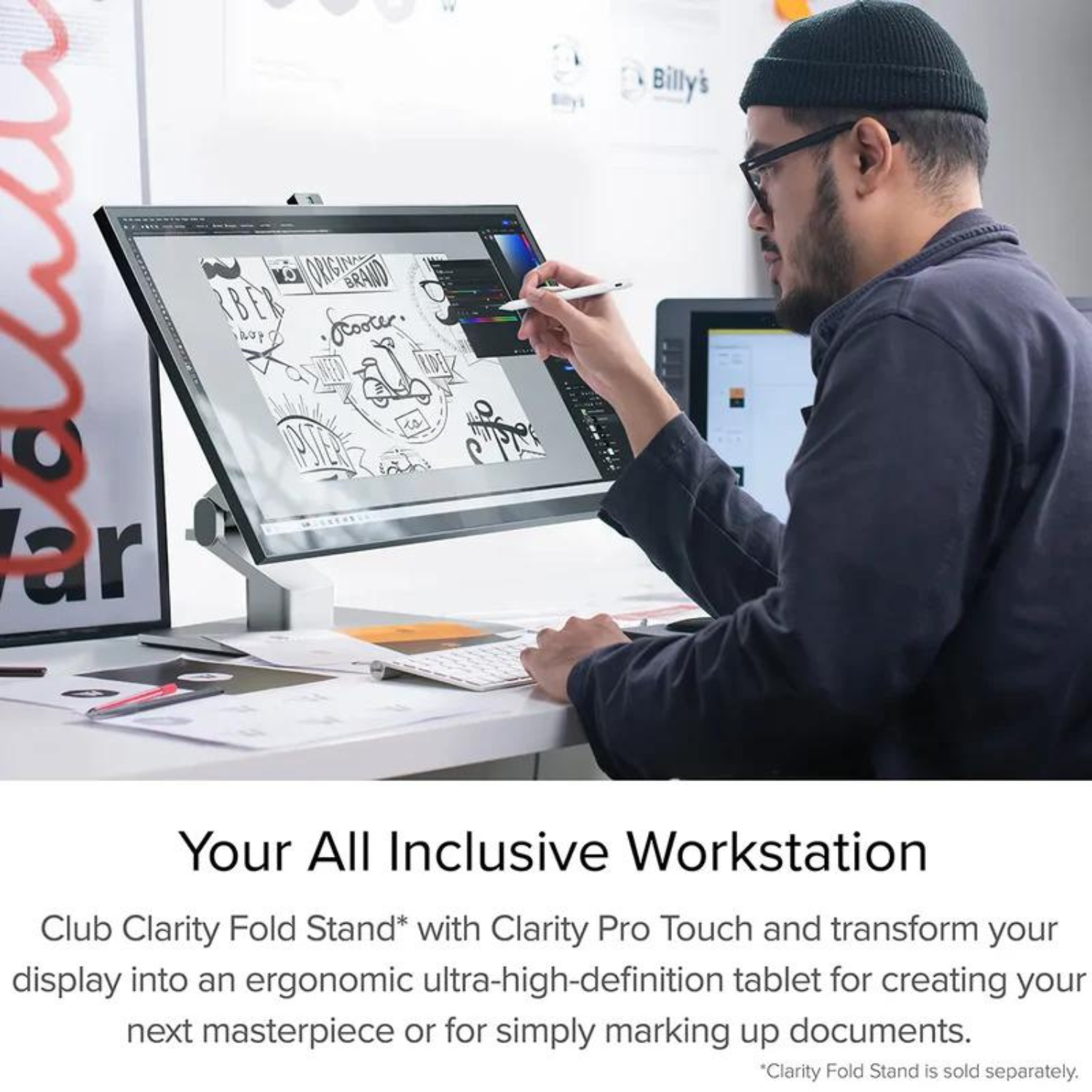 Osoba używająca pióra na dużym ekranie, z klawiaturą i innymi przedmiotami na biurku.