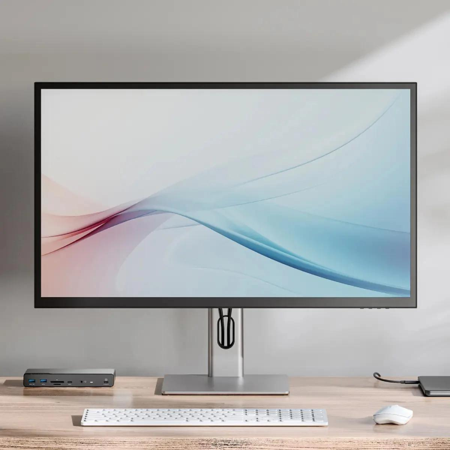 Un monitor, tastiera, mouse e docking station su una scrivania.