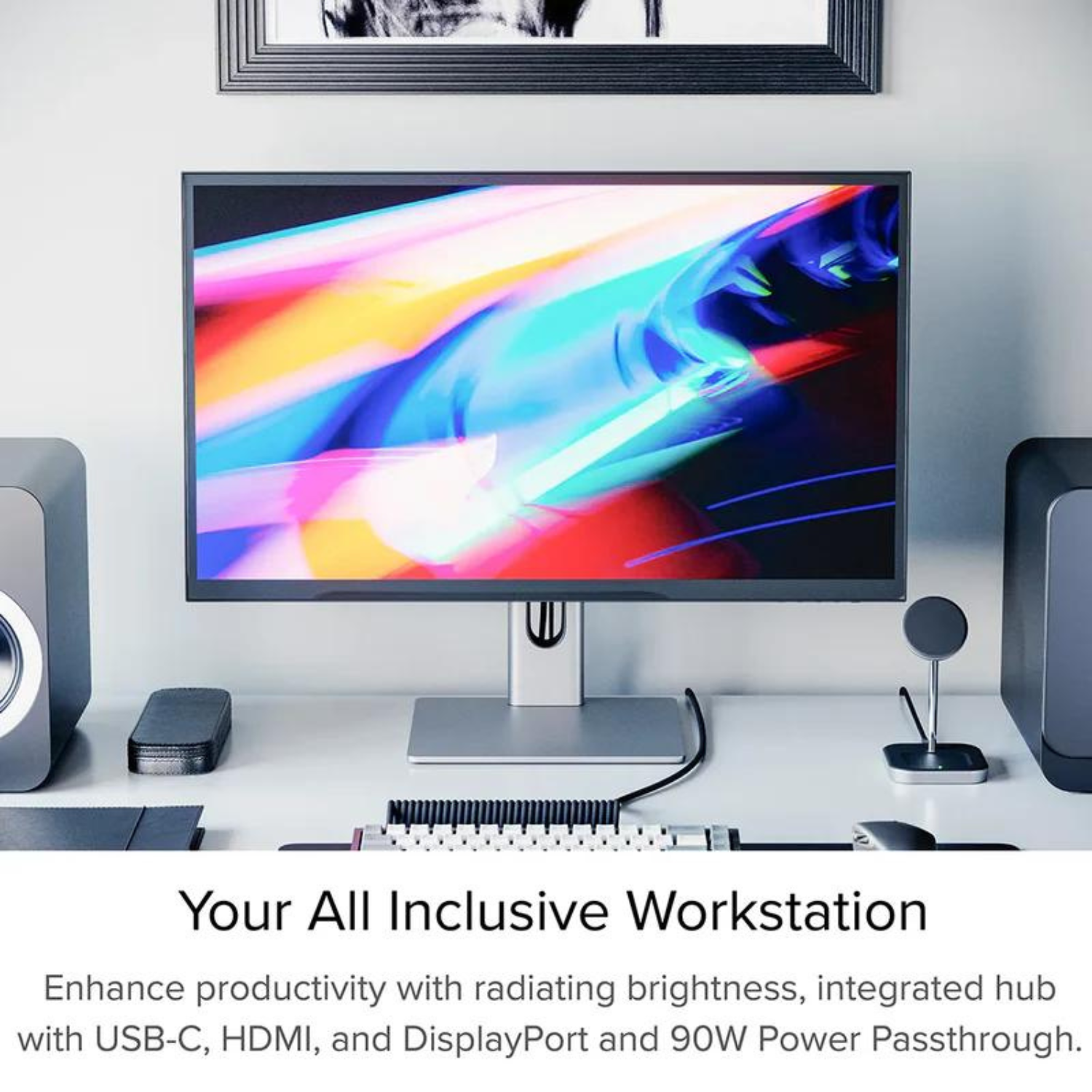 Configurazione scrivania con monitor che mostra immagine colorata, altoparlanti, tastiera e accessori.