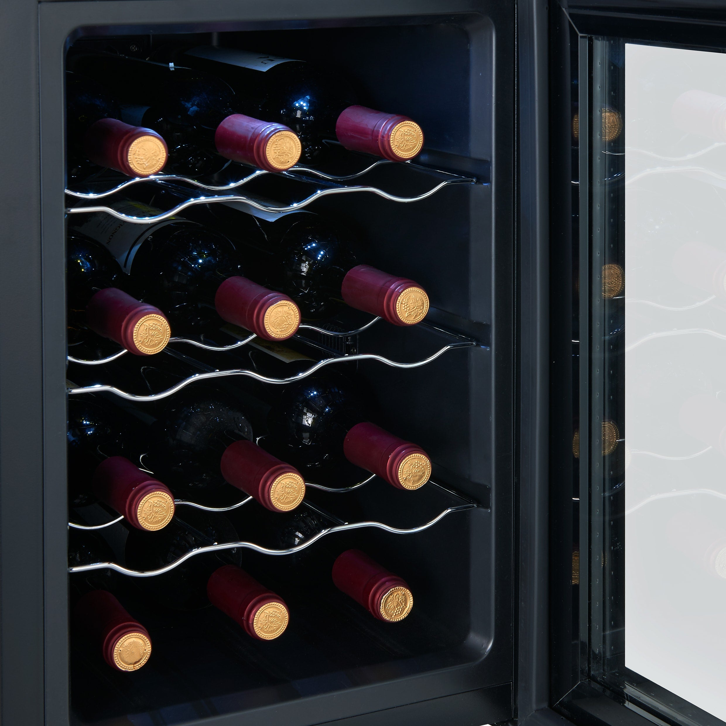 A wine cooler with several bottles of red wine visible through the glass door and inside.