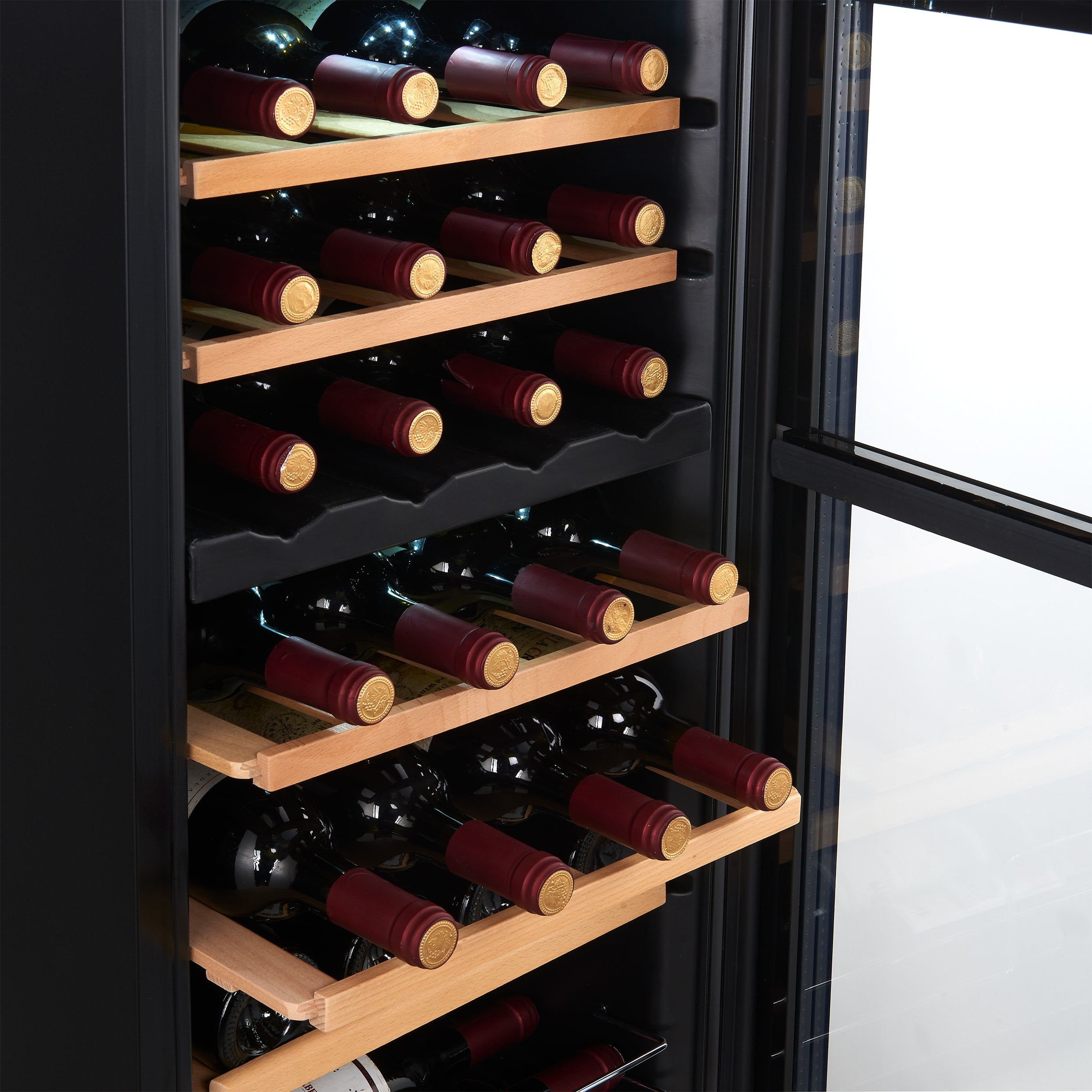 Wine cooler with multiple shelves holding red wine bottles against a dark background.