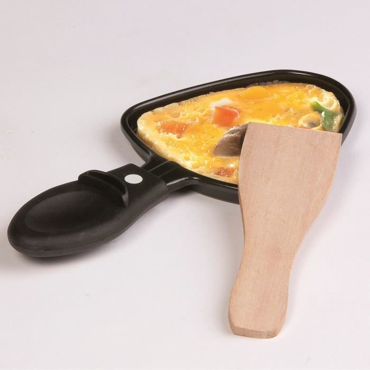 Kleine Pfanne mit gekochtem Essen. Ein Holzspatel liegt daneben.