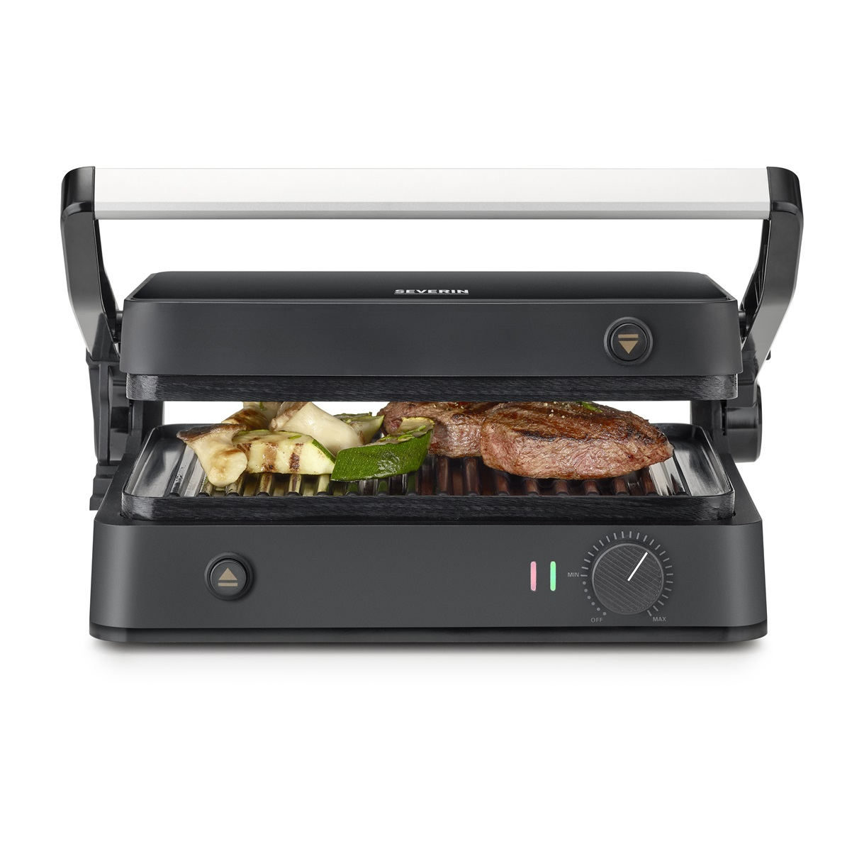 Black grill with food on it. Grilled meat and vegetables are visible. The grill is on a white background.