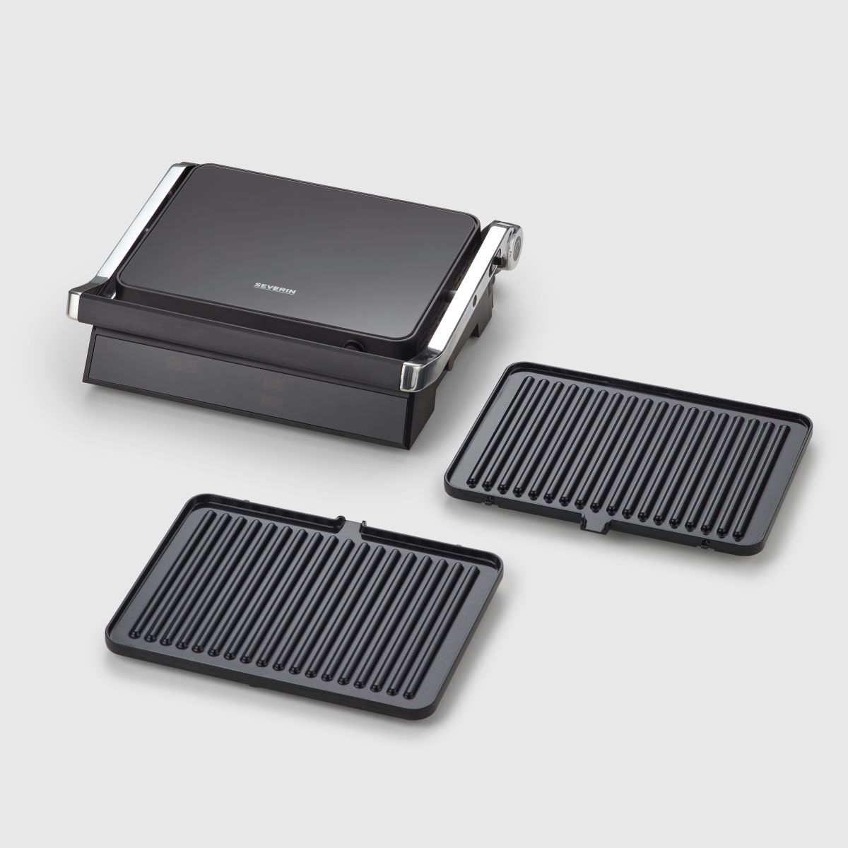 Ein schwarzer Elektrogrill mit zwei herausnehmbaren Grillplatten. Der Grill ist geschlossen. Grillplatten sind daneben sichtbar.