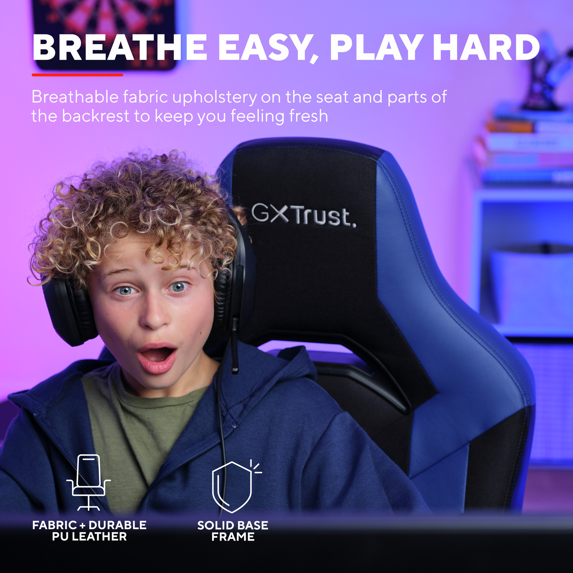 Ein Junge mit Kopfhörern sitzt in einem blau-schwarzen Gaming-Stuhl und sieht überrascht aus.