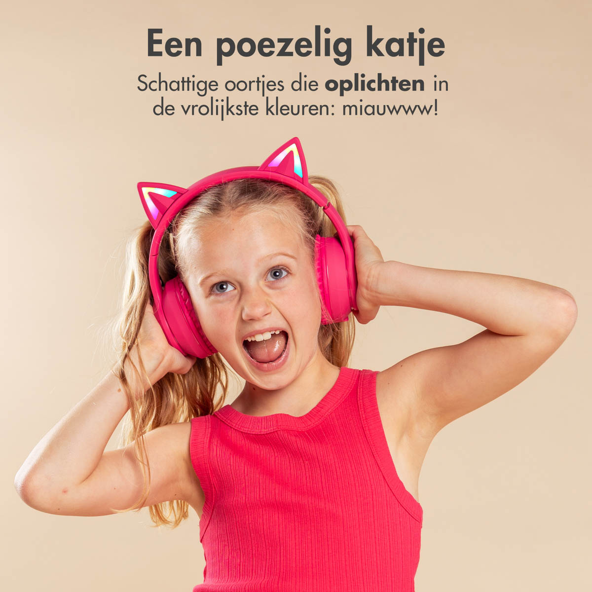 Ragazza con cuffie rosa a forma di orecchie di gatto, sorridente e che guarda la fotocamera.