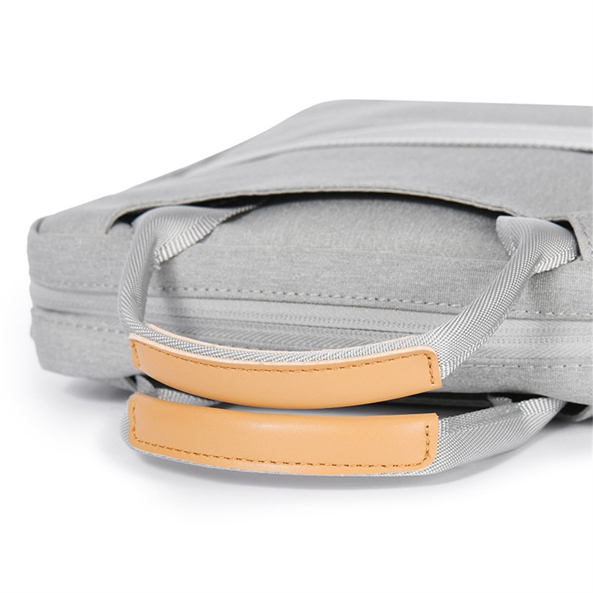 Nahaufnahme einer grauen Tasche mit braunen Griffen.