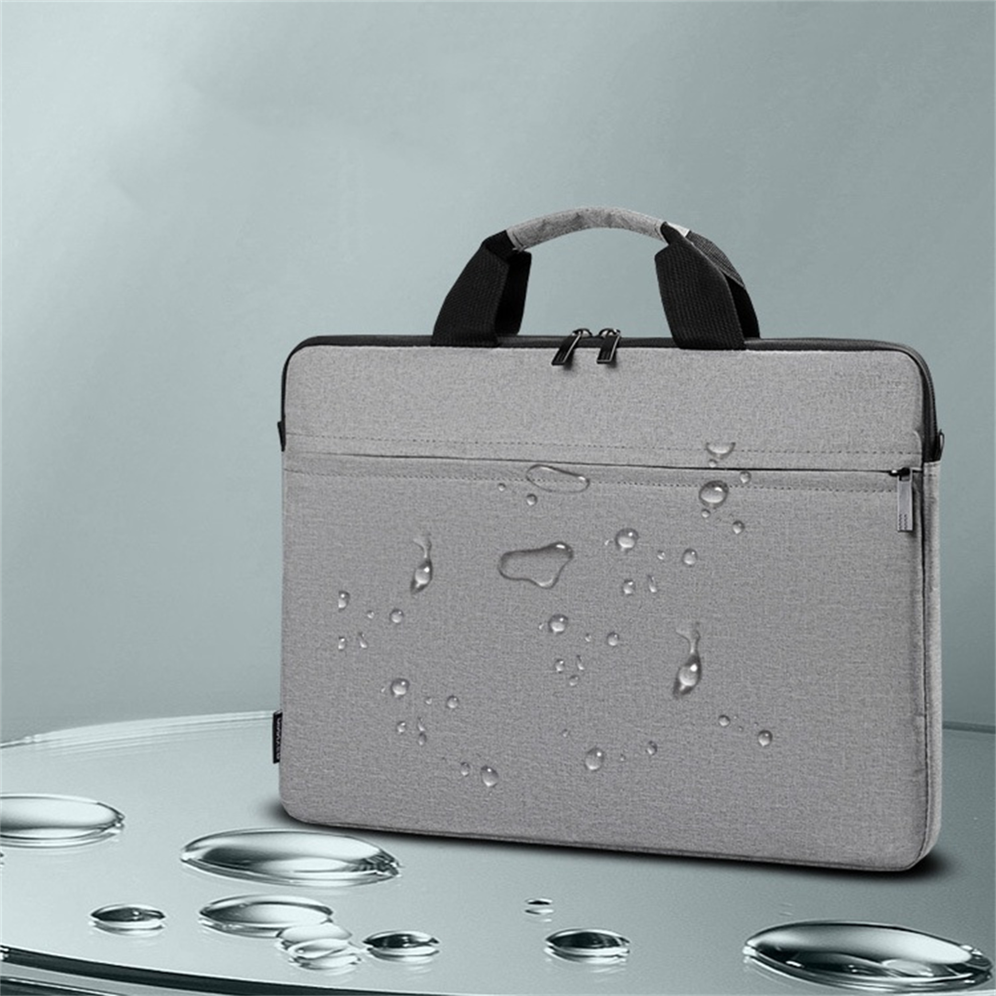 Graue, wasserdichte Laptoptasche mit Wassertropfen auf reflektierender Oberfläche.