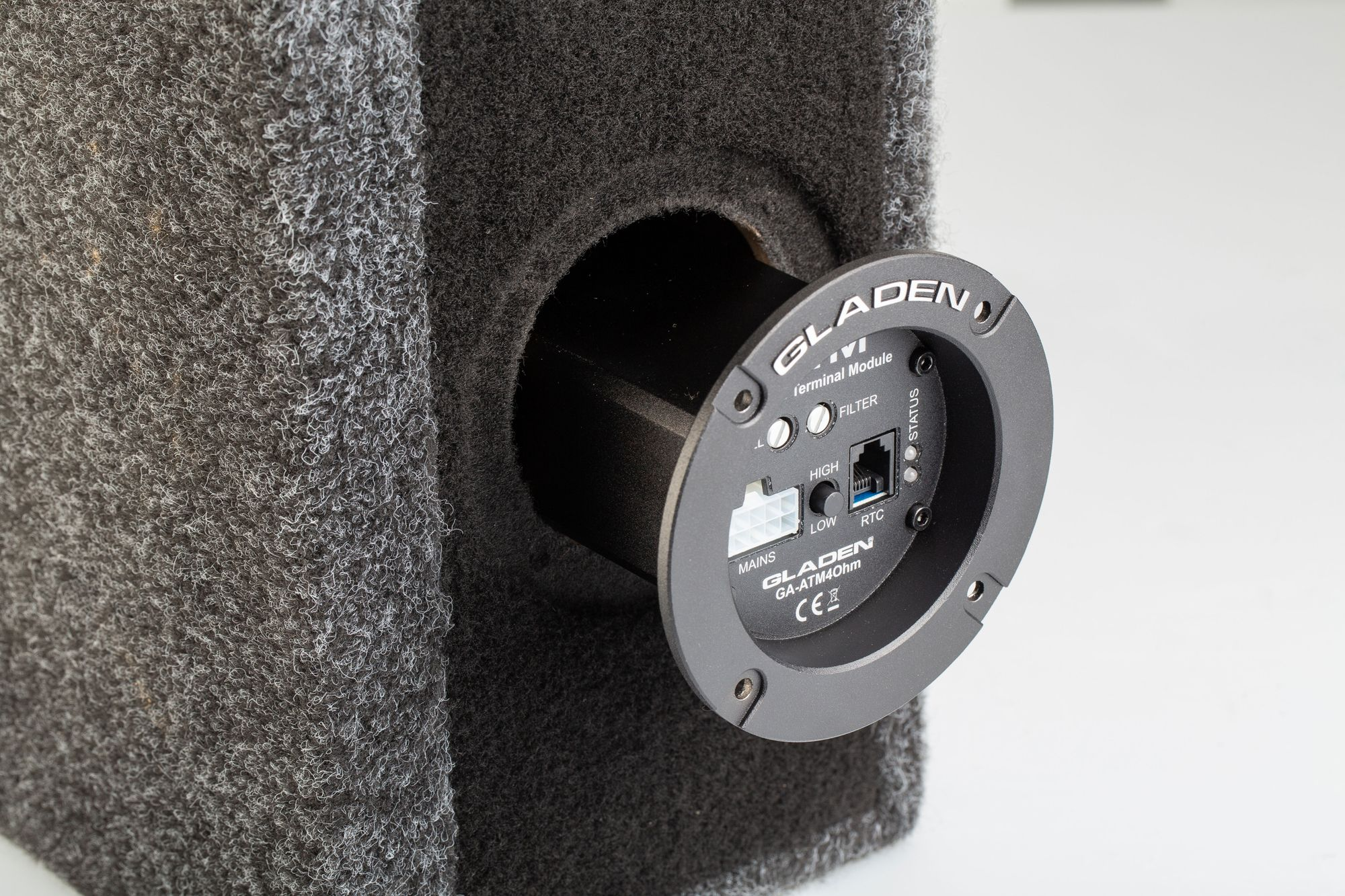 Eine schwarze Subwoofer-Komponente mit Loch und Gladen-Anschlussmodul.