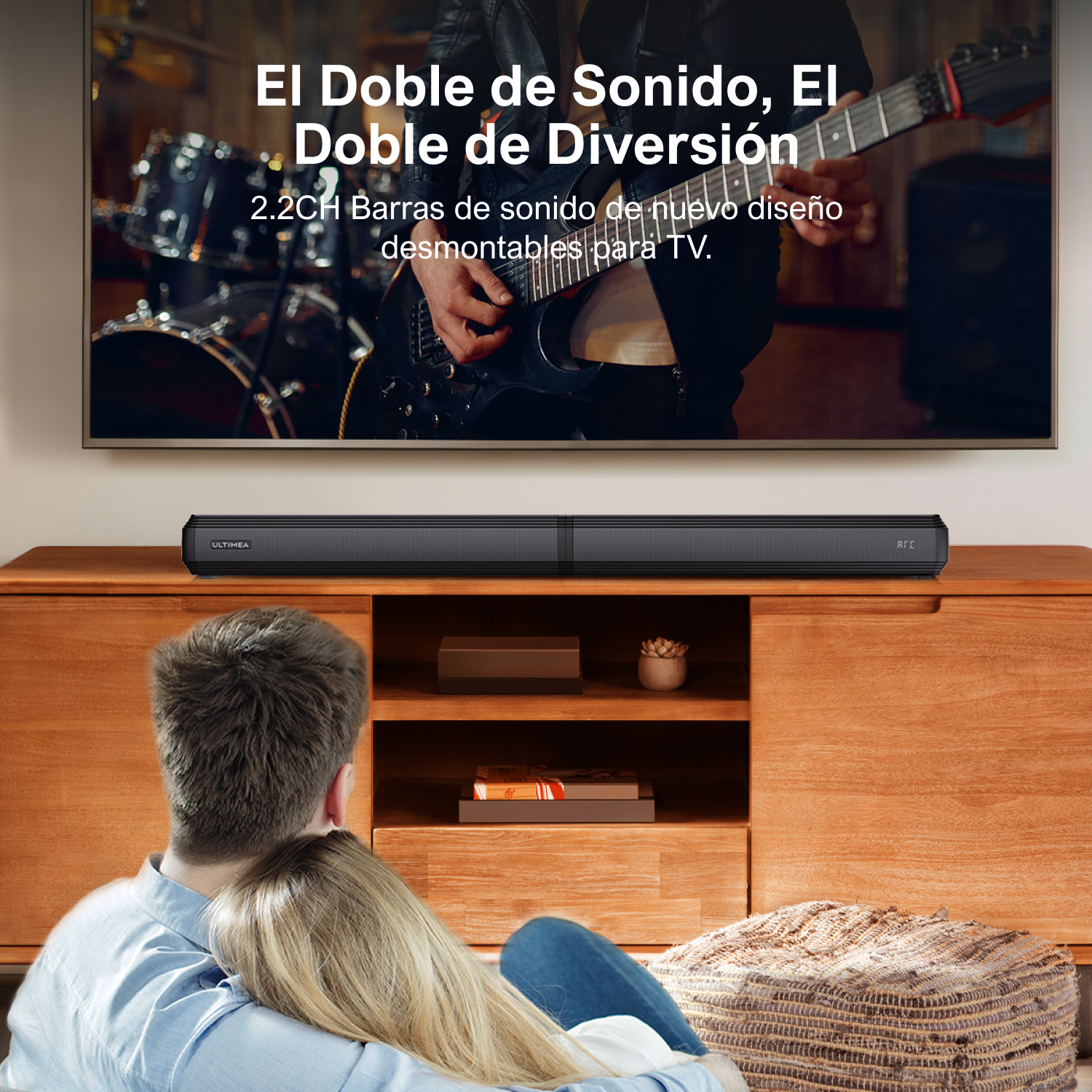 Pareja viendo la televisión, barra de sonido debajo, mueble de madera, ambiente acogedor.
