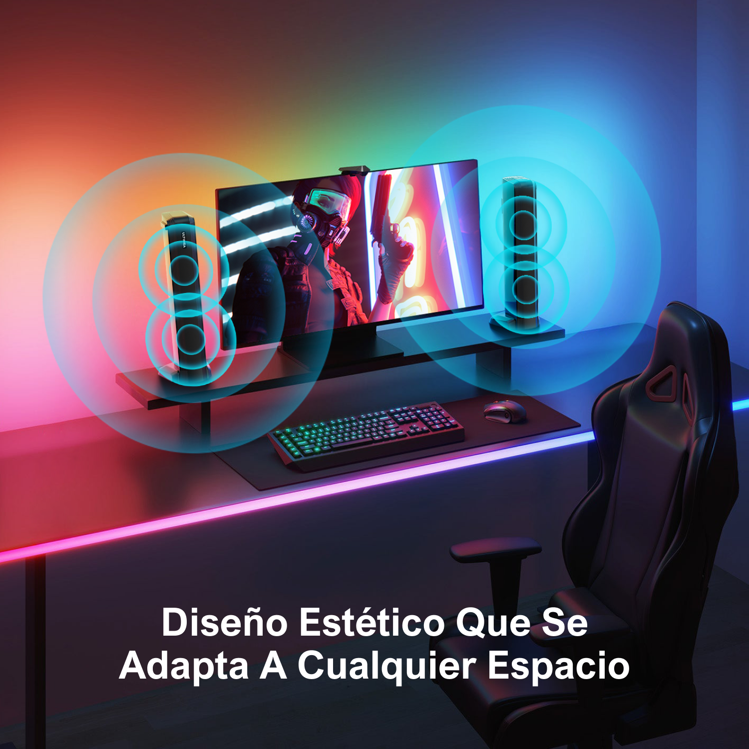 Configuración de juego con monitor, altavoces, teclado y silla con iluminación ambiental.