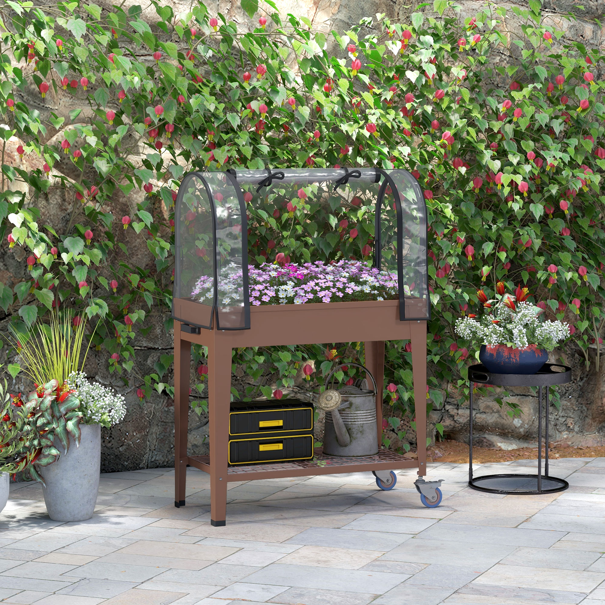 Aiuola rialzata con piante, circondata da fiori e un muro di mattoni. Dispone di una copertura in vetro.