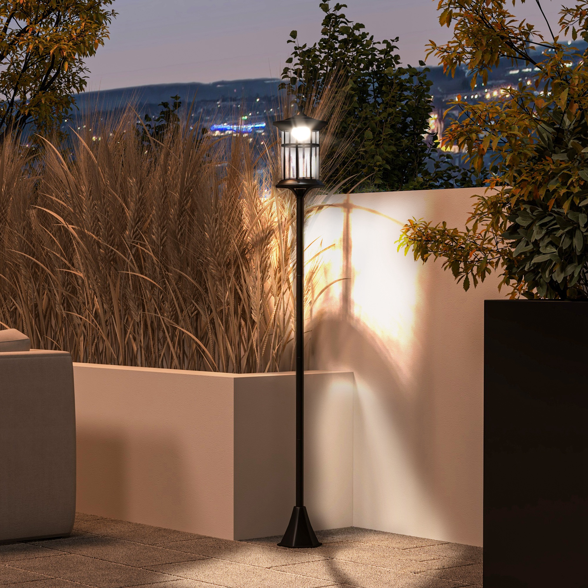 Un lampione nero con una lanterna illuminata su un patio di notte. Gli alberi incorniciano la scena.
