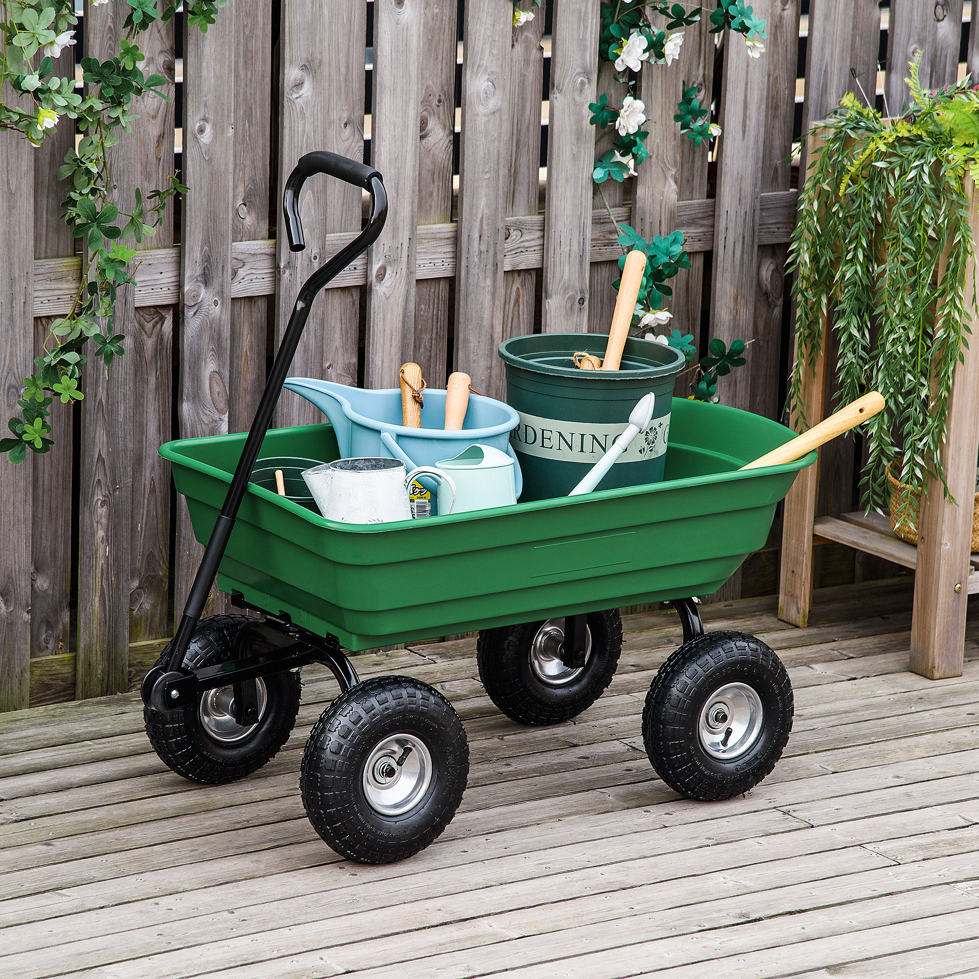 Carrello da giardino verde con vari attrezzi da giardinaggio all'interno, su un ponte di legno.