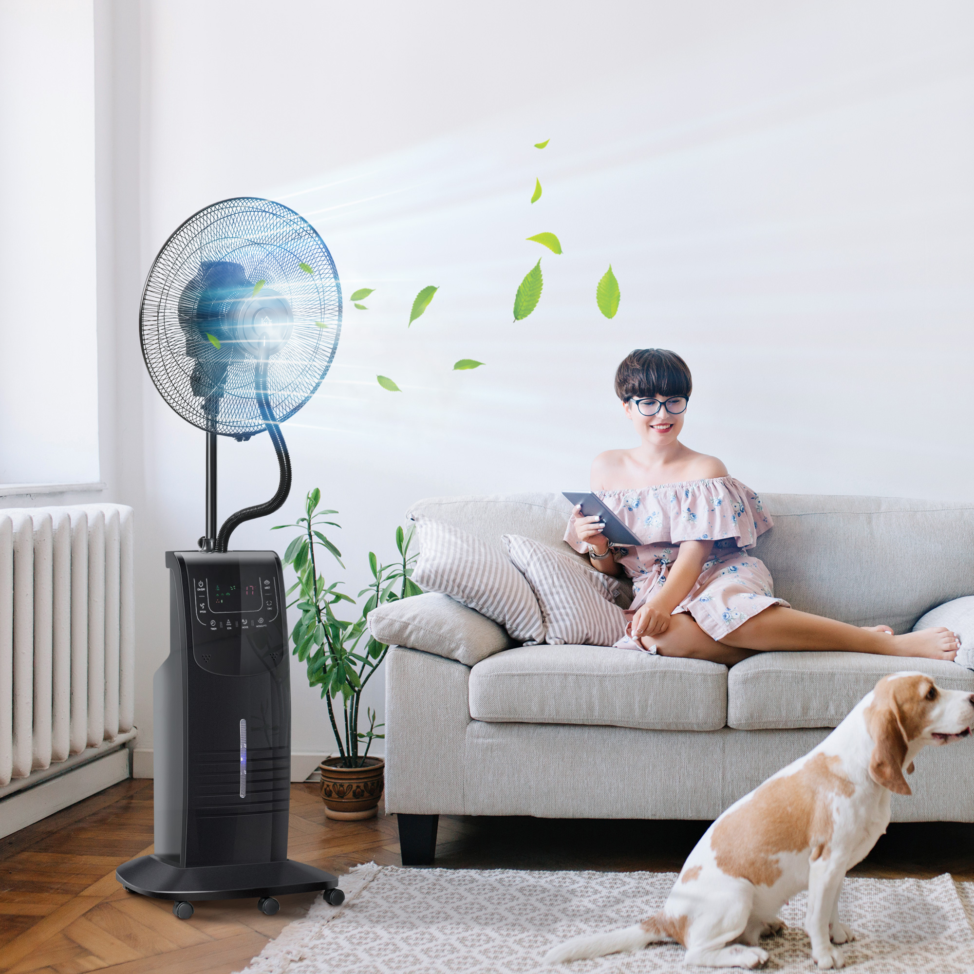 Mujer en un sofá con una tableta, un ventilador de pie soplando aire y un perro sentado cerca.