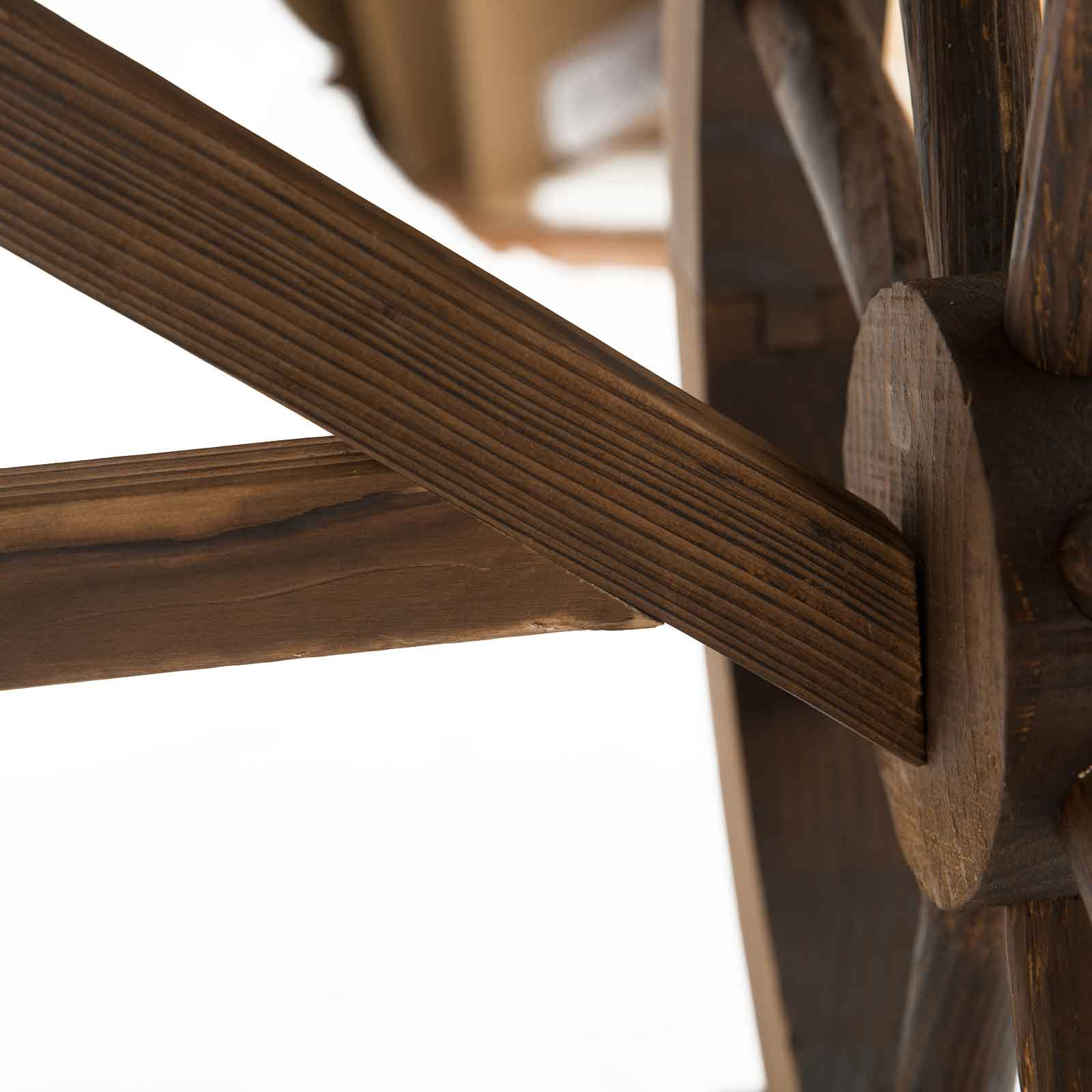 Primo piano dei raggi di una ruota in legno. Il legno è marrone e presenta venature visibili. I raggi si incrociano al centro.