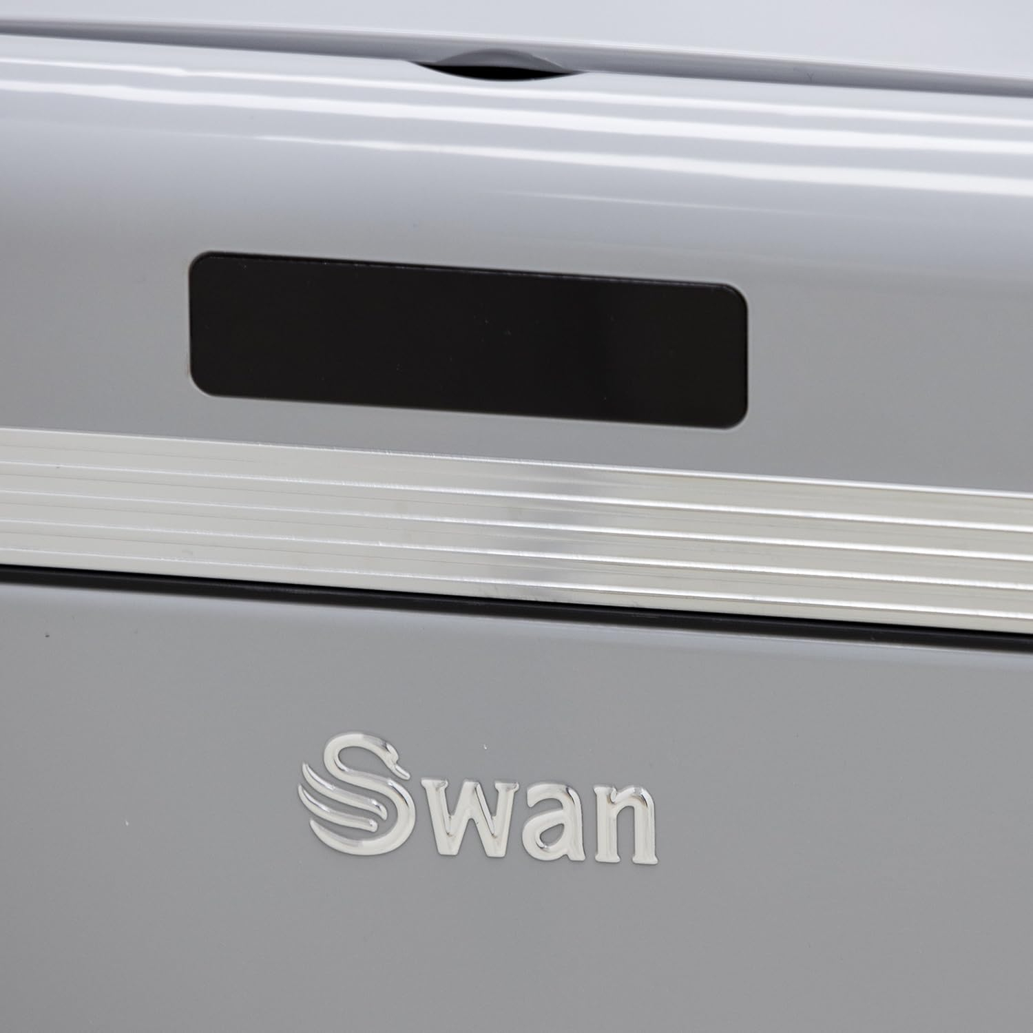 Un primer plano de un electrodoméstico gris con la palabra 'Swan' en letras cromadas.