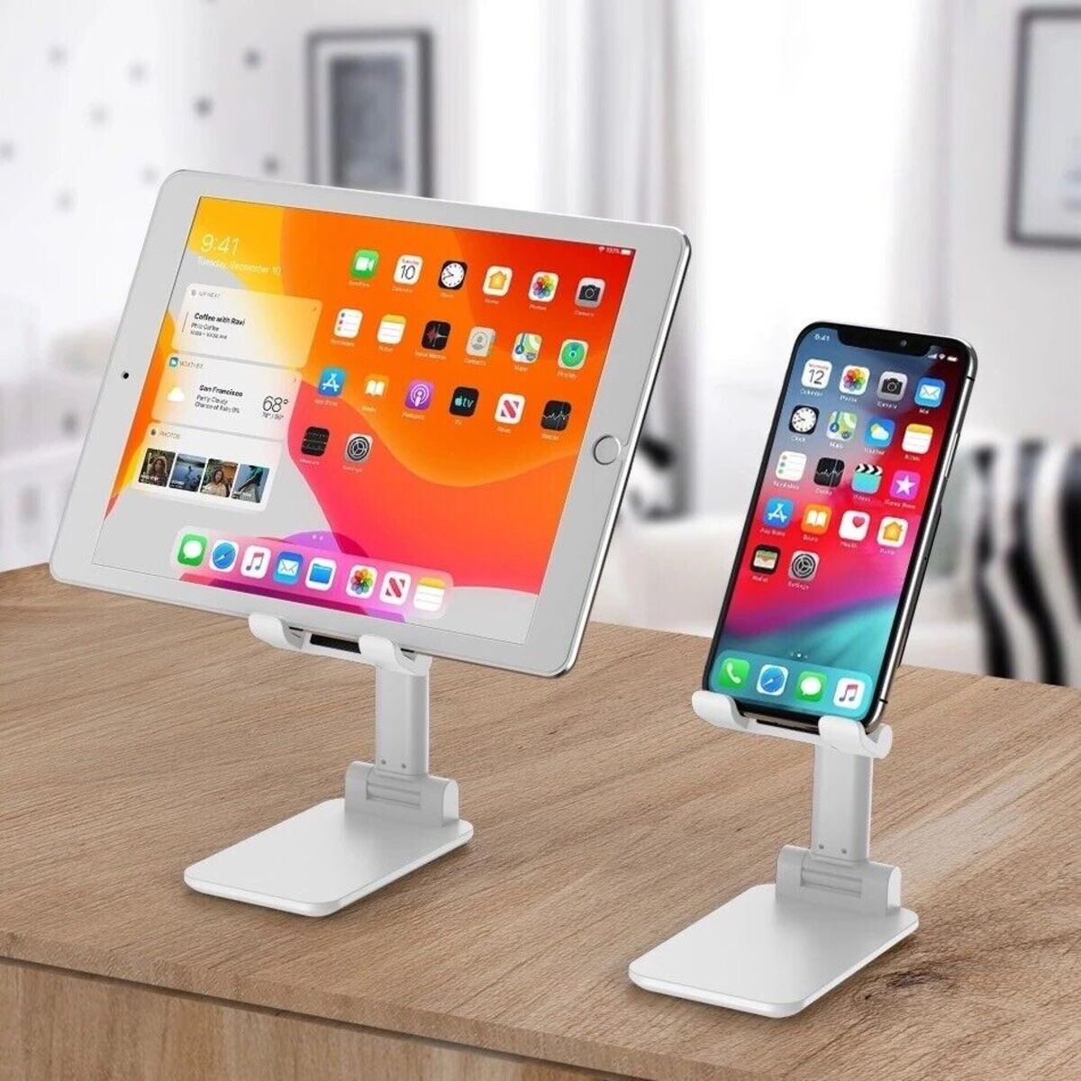 Ein Tablet und ein Telefon auf weißen Ständern auf einem Holztisch. Beide Geräte sind eingeschaltet.