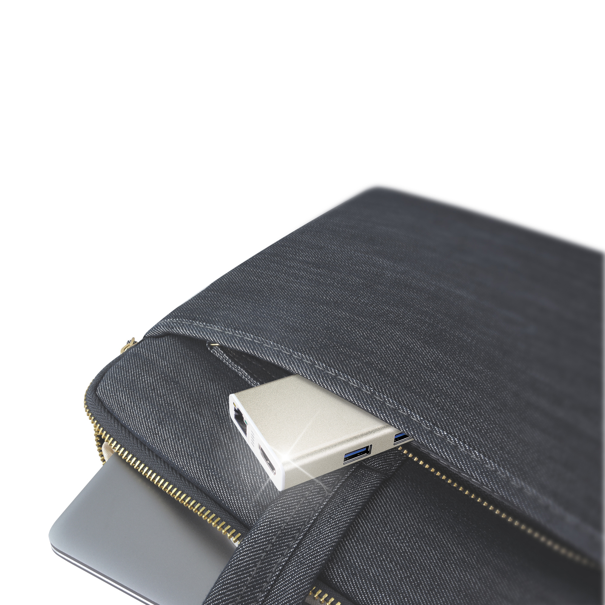 Ein silberner USB-Hub befindet sich in einer schwarzen Jeans-Laptoptasche. Die Tasche ist offen und der Reißverschluss ist sichtbar.