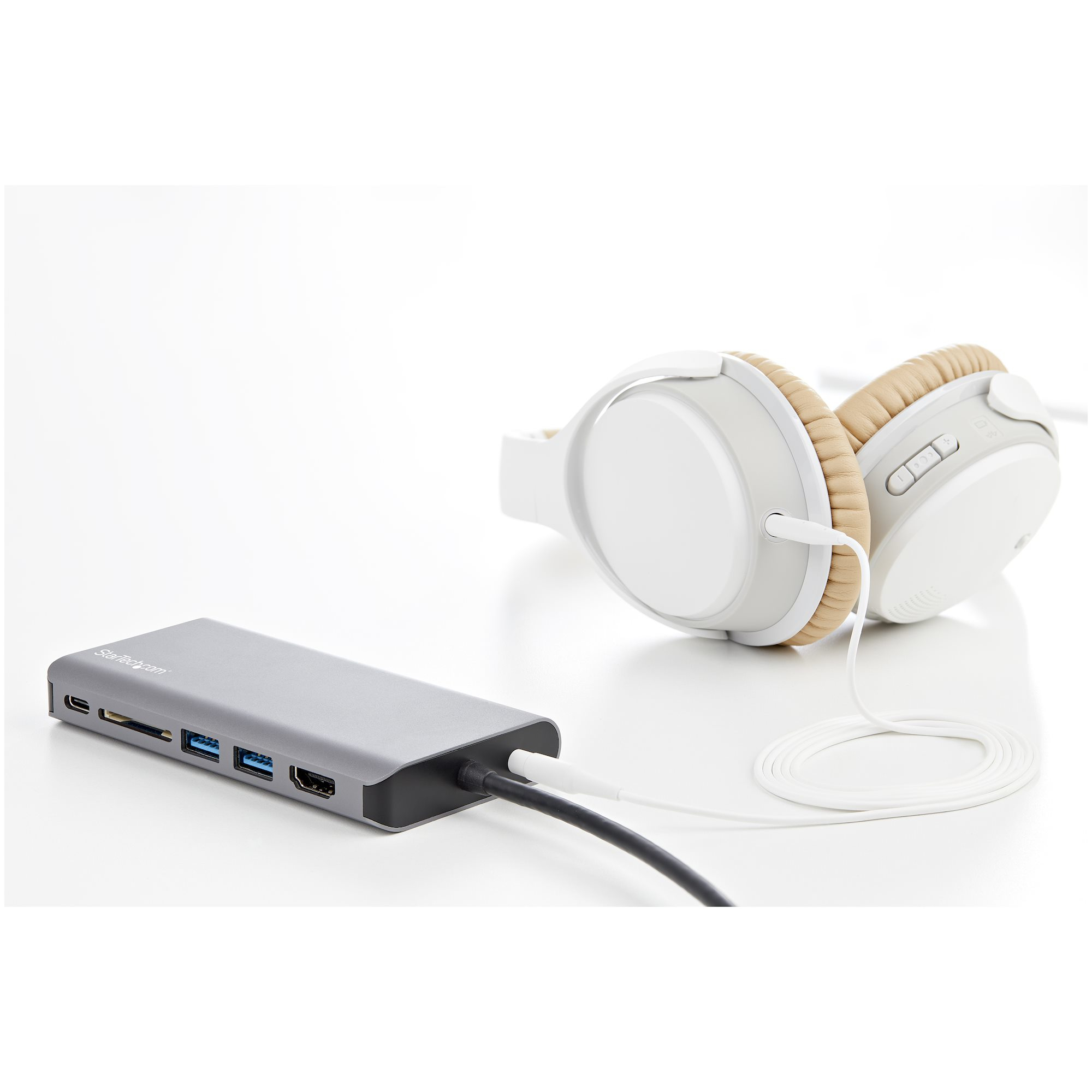 Hub USB argento con cuffie su sfondo bianco.