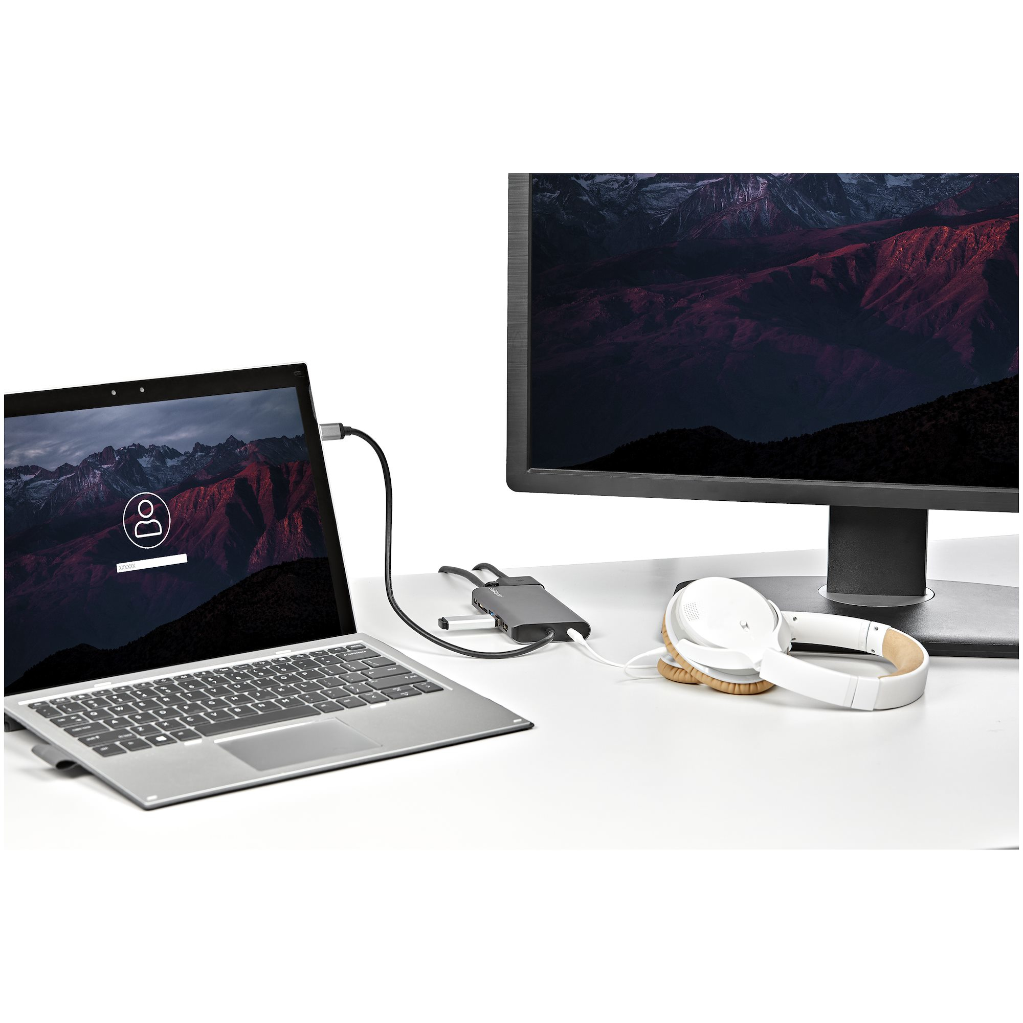 Un laptop collegato a un monitor, cuffie e un hub.