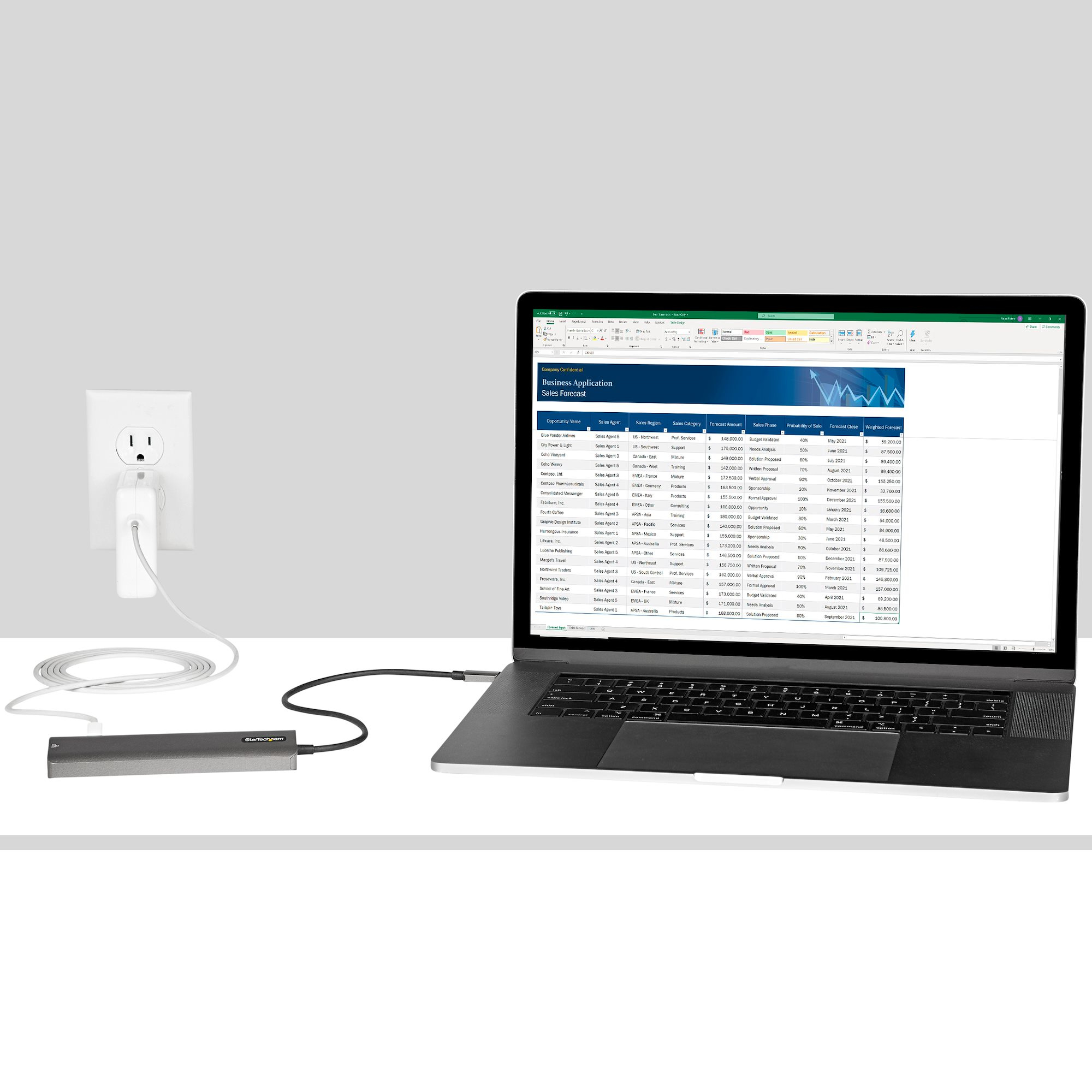 Ein Laptop, der mit einem externen Gerät verbunden ist, das an eine Steckdose angeschlossen ist, zeigt eine Tabelle.