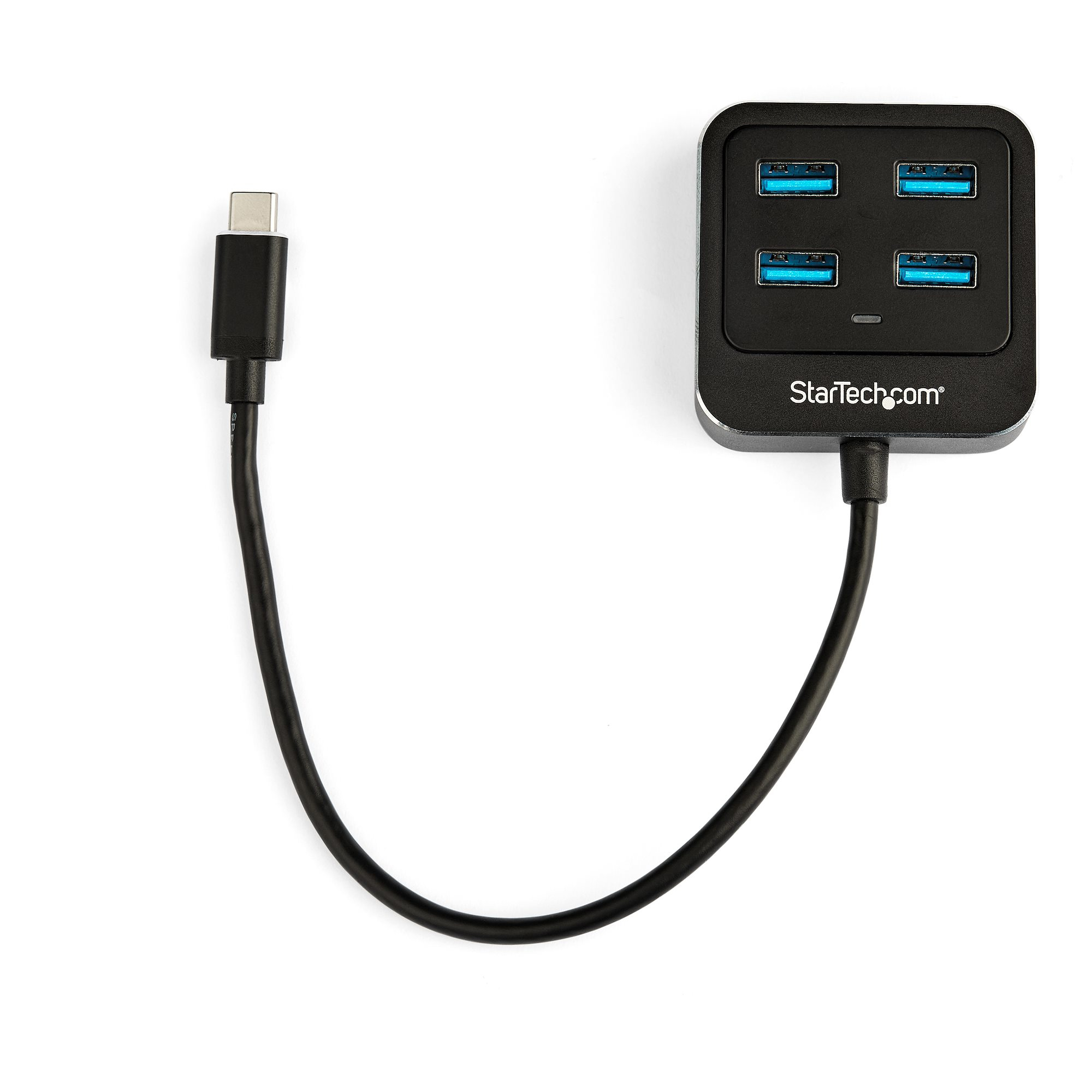 Un concentrador USB negro con cuatro puertos USB azules y un cable USB-C negro conectado sobre una superficie blanca.
