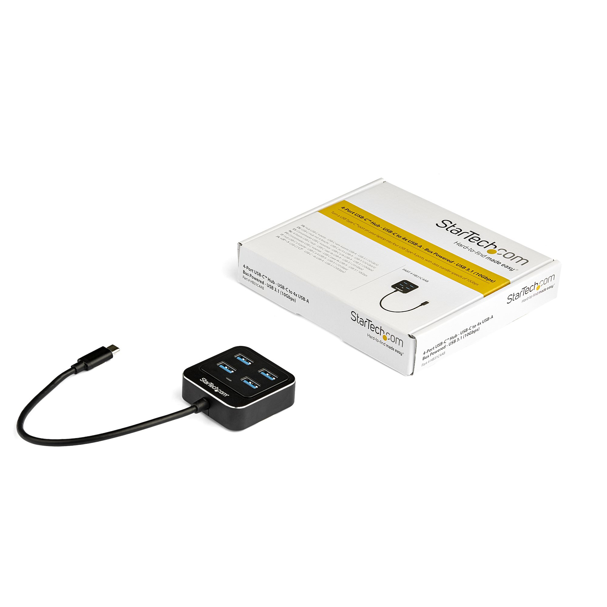 Concentrador USB negro con cuatro puertos y cable conectado, caja con logo Startech.com.
