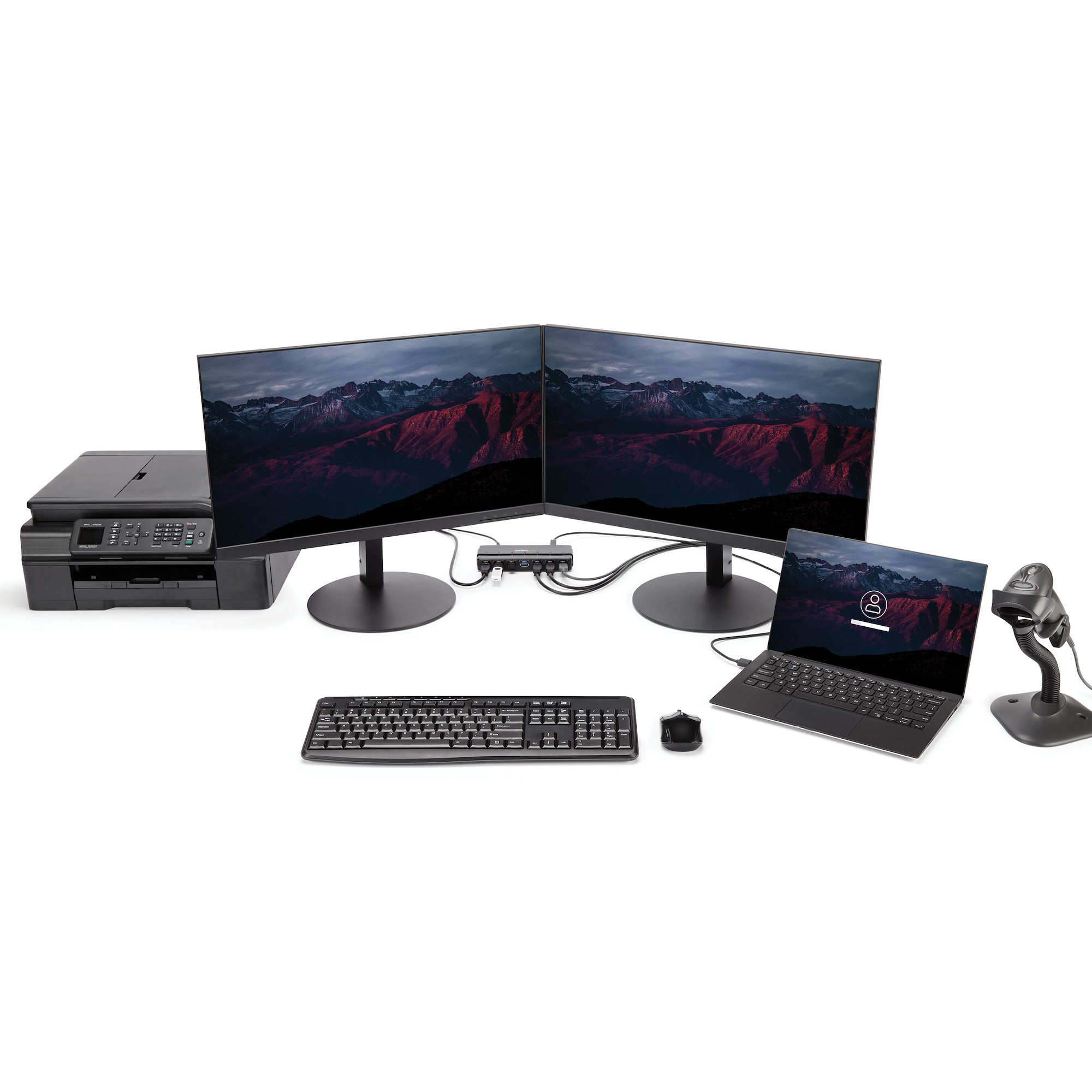 Configurazione ufficio con due monitor, stampante, laptop, tastiera, mouse e scanner di codici a barre.