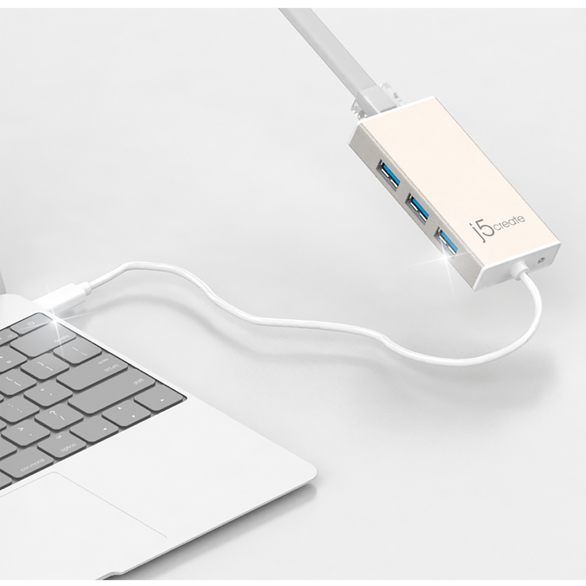 Goldener USB-Hub, der mit einem Laptop mit weißem Kabel verbunden ist.