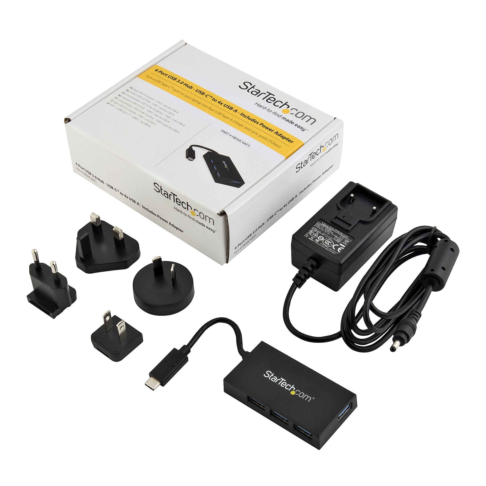 Eine Box mit USB-Adaptern, Steckern und einem Netzteil, alles auf weißem Hintergrund.