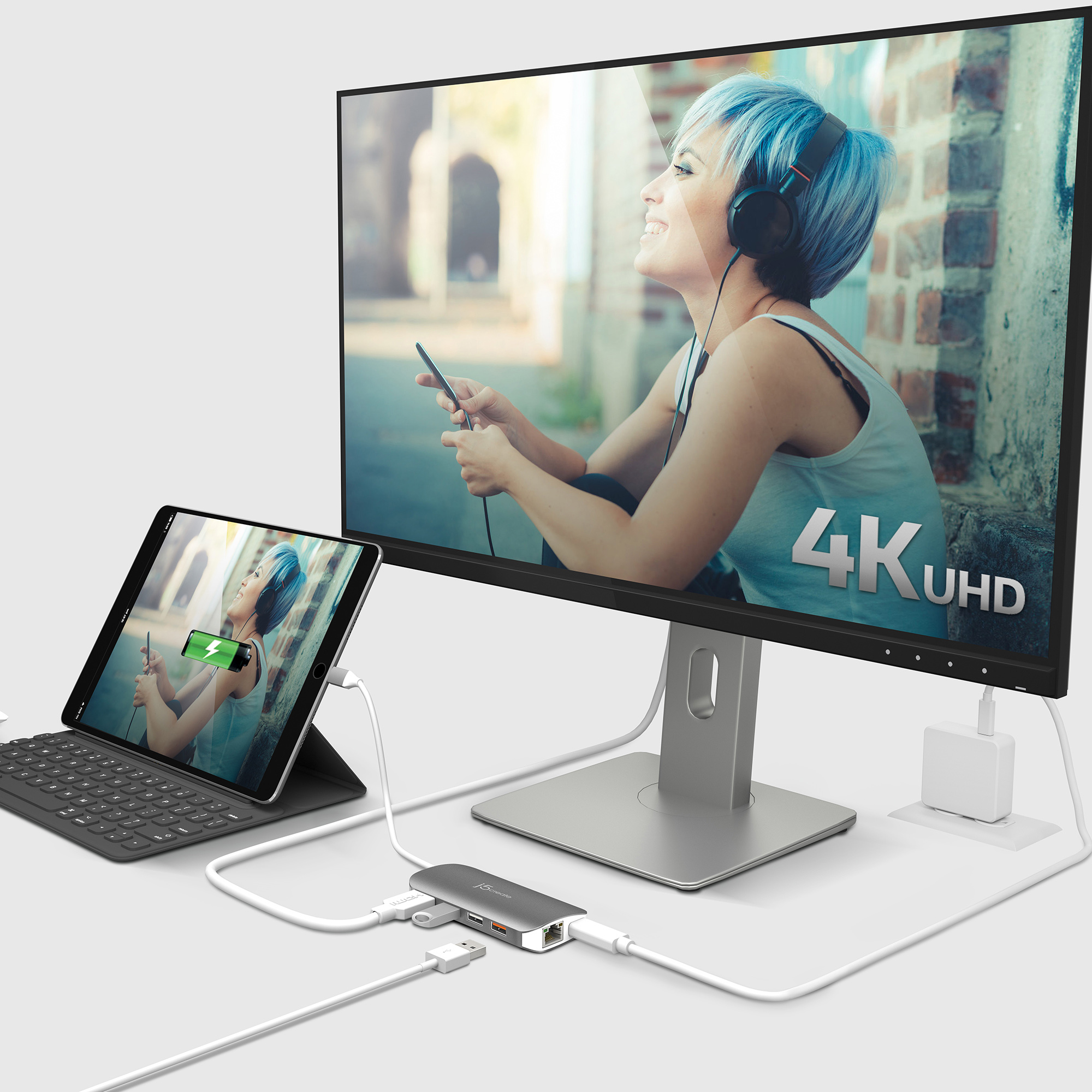 Tablet und Monitor sind mit einem Hub verbunden. Der Monitor zeigt eine Frau mit blauen Haaren.