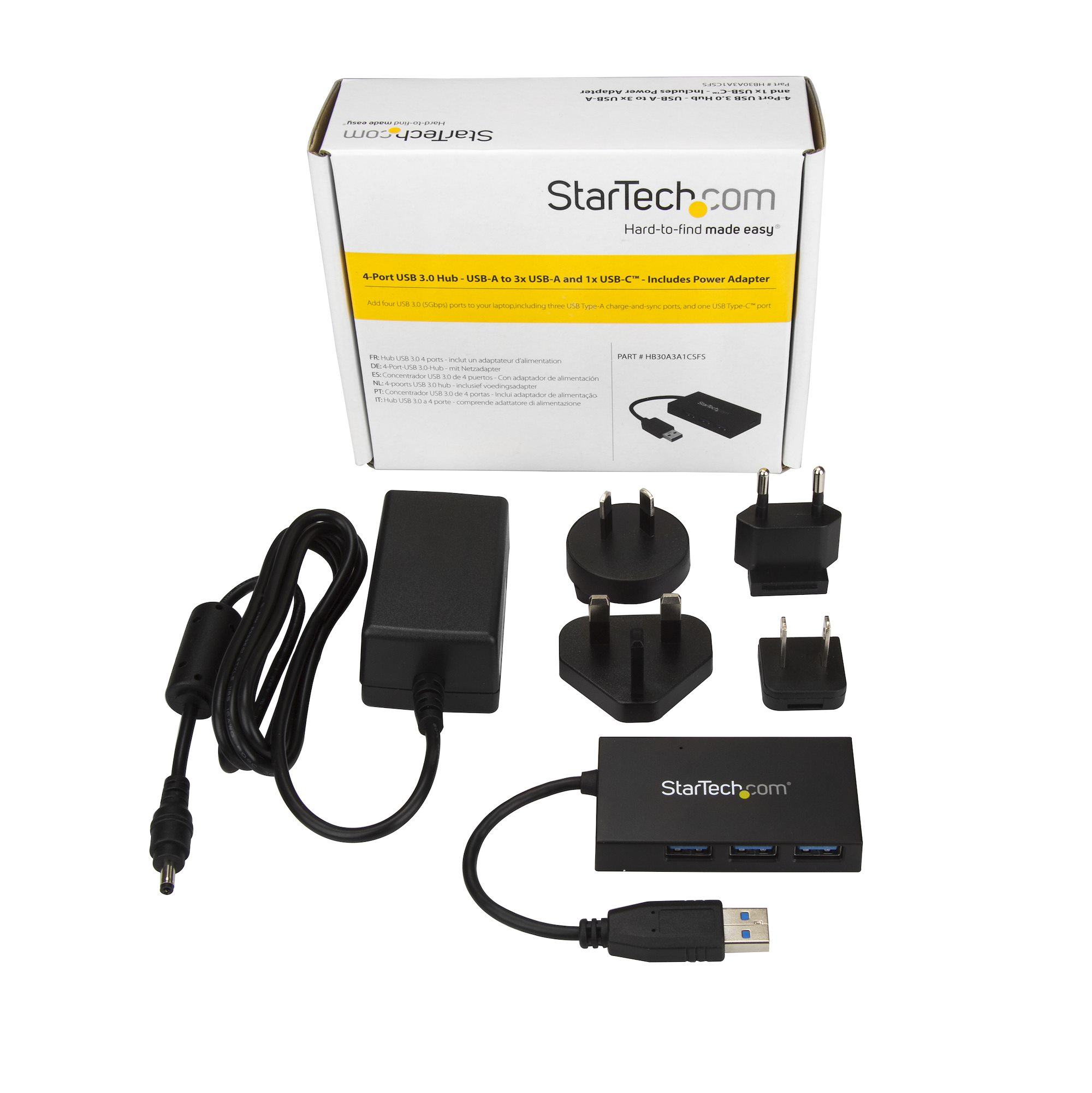 Caja blanca con un concentrador USB negro y varios adaptadores de enchufe. La caja tiene texto.