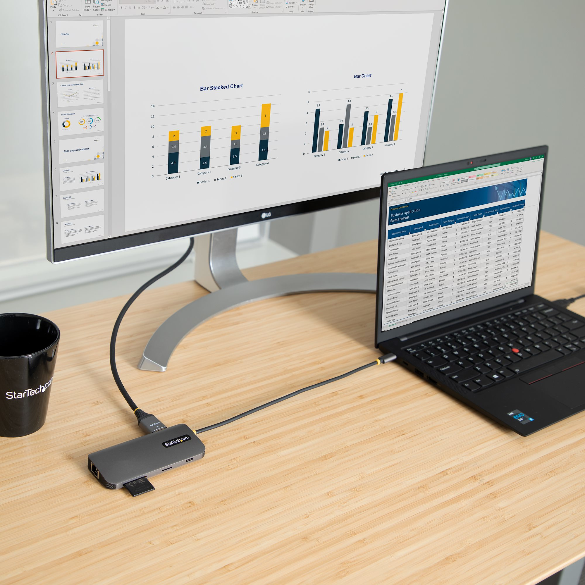 Ordenador portátil conectado a un monitor. Hub, taza y gráfico en un escritorio de madera.