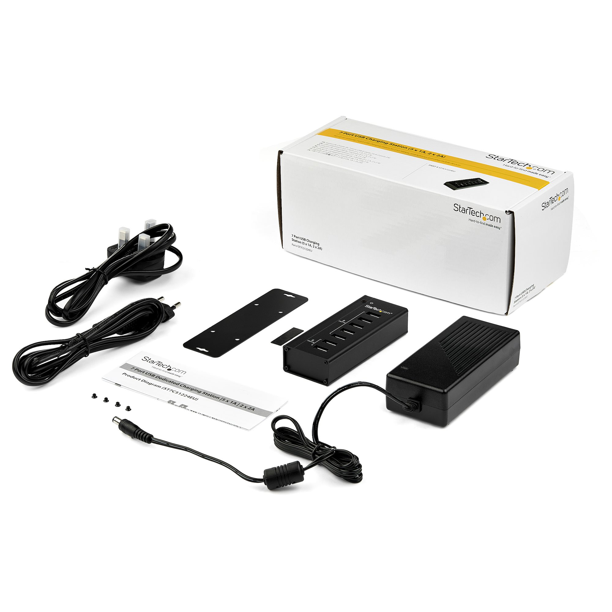 Una caja con un concentrador USB negro y otros accesorios en superficie blanca.
