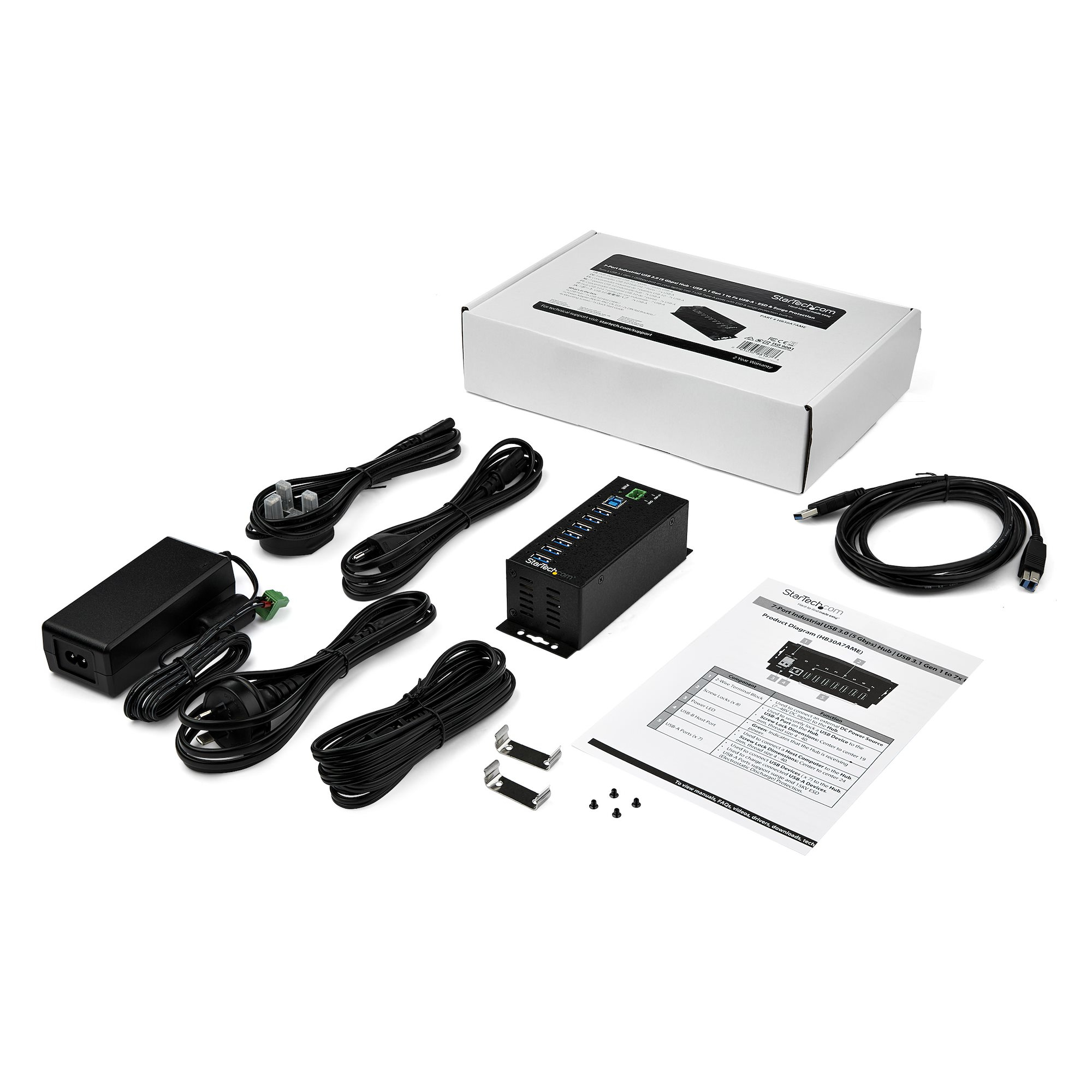 Varios componentes electrónicos, cables y un manual sobre una superficie blanca.