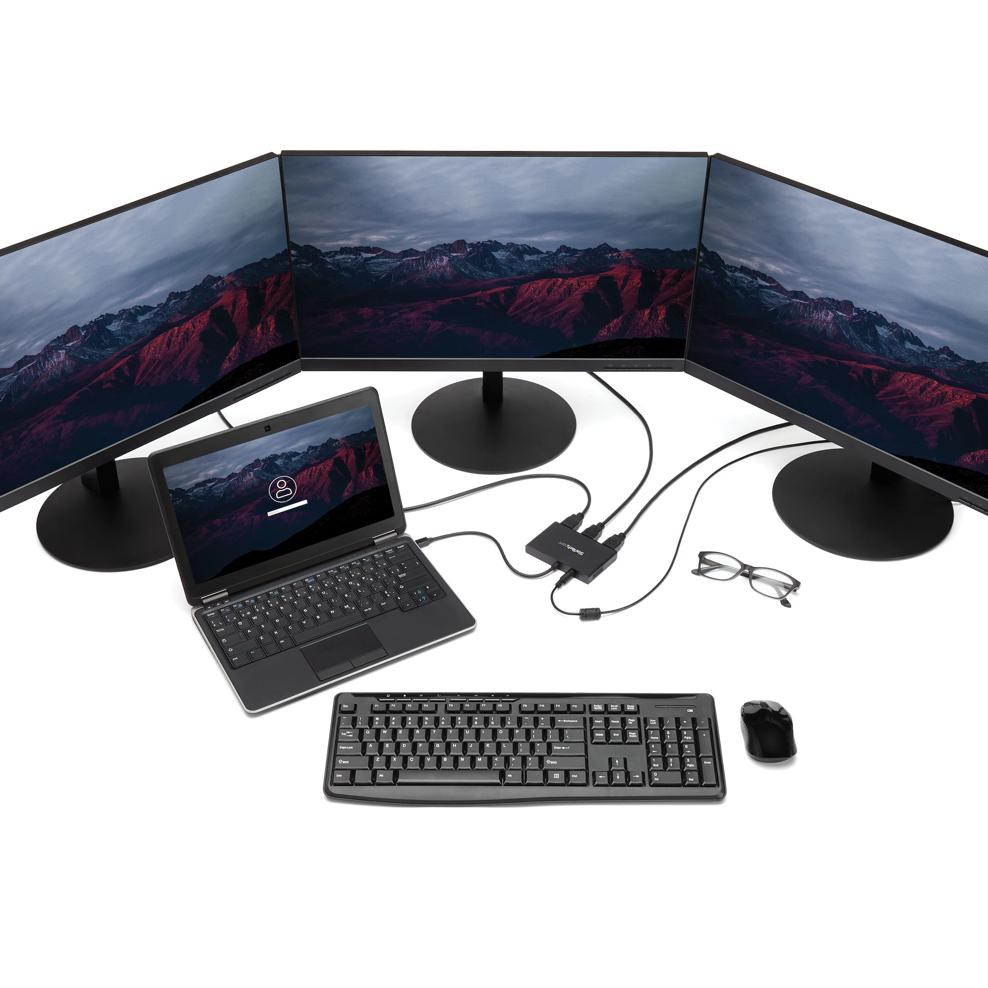 Più monitor, tastiera, mouse e un laptop, collegati a un hub.