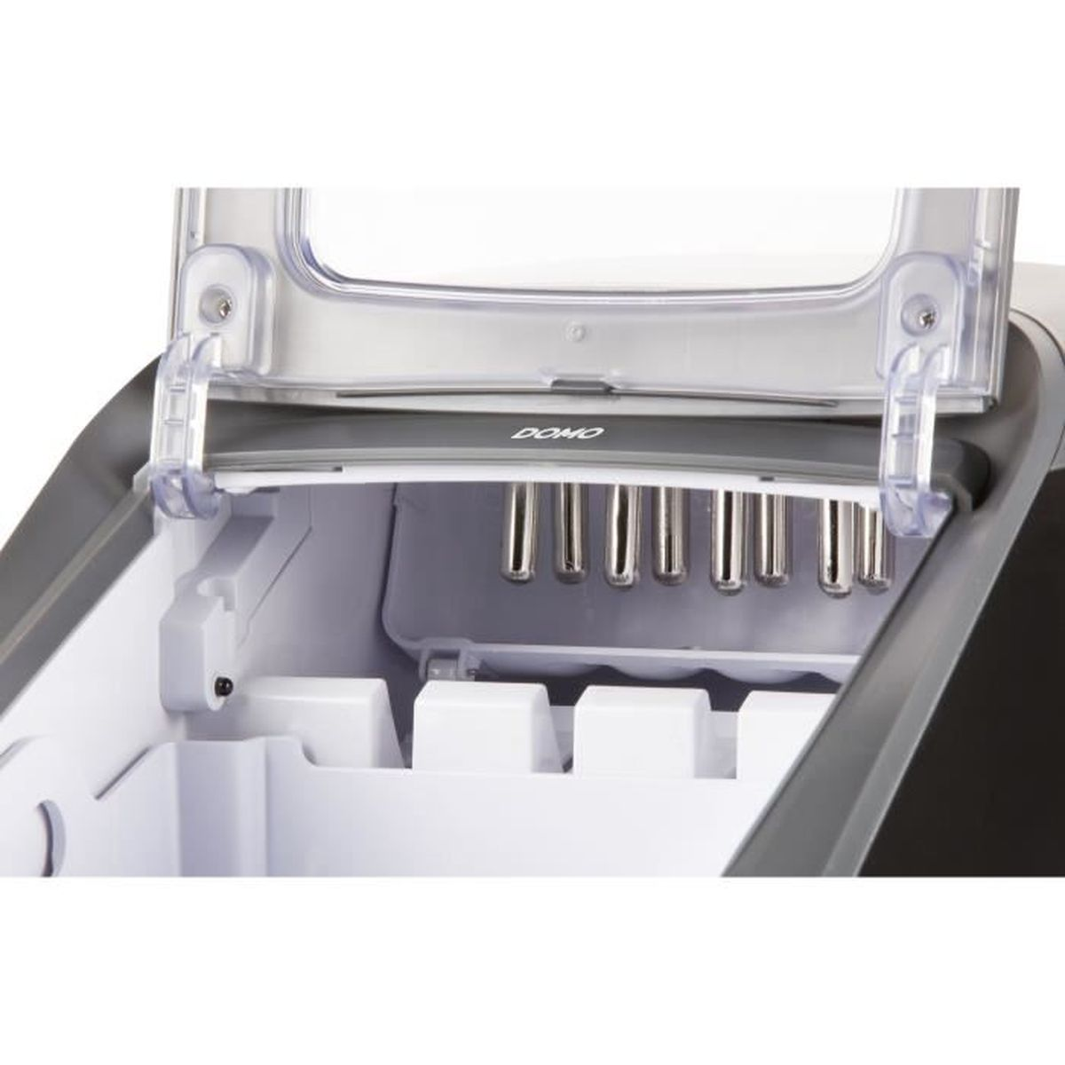 Wnętrze kostkarki do lodu. Pokrywa jest otwarta. Są metalowe pręty i białe formy na lód.