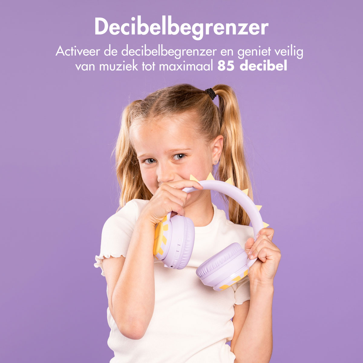 Meisje met paarse koptelefoon, glimlachend, voor een paarse achtergrond.