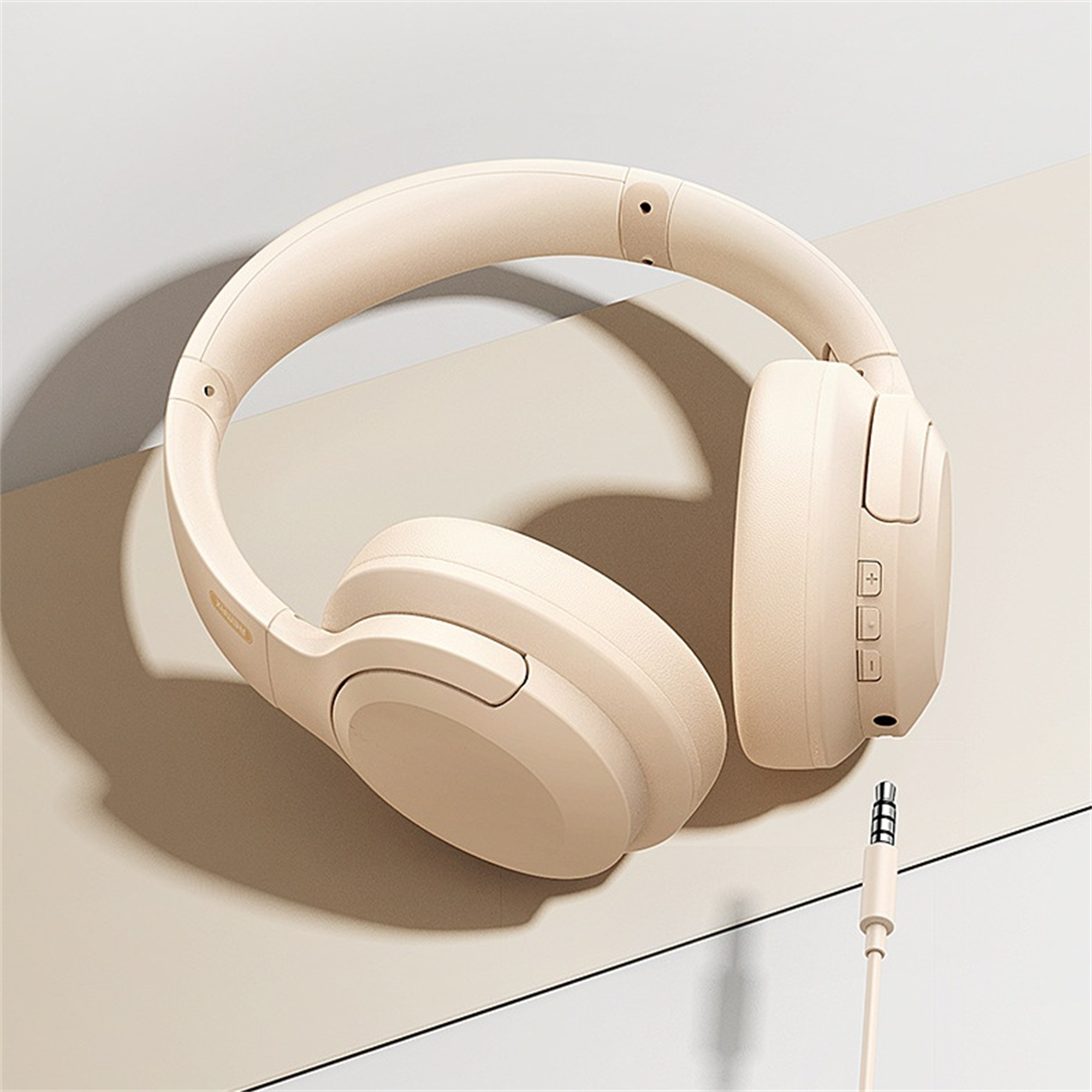 Beige Over-Ear-Kopfhörer mit Bedienelementen rechts, Kabel mit Klinkenstecker.