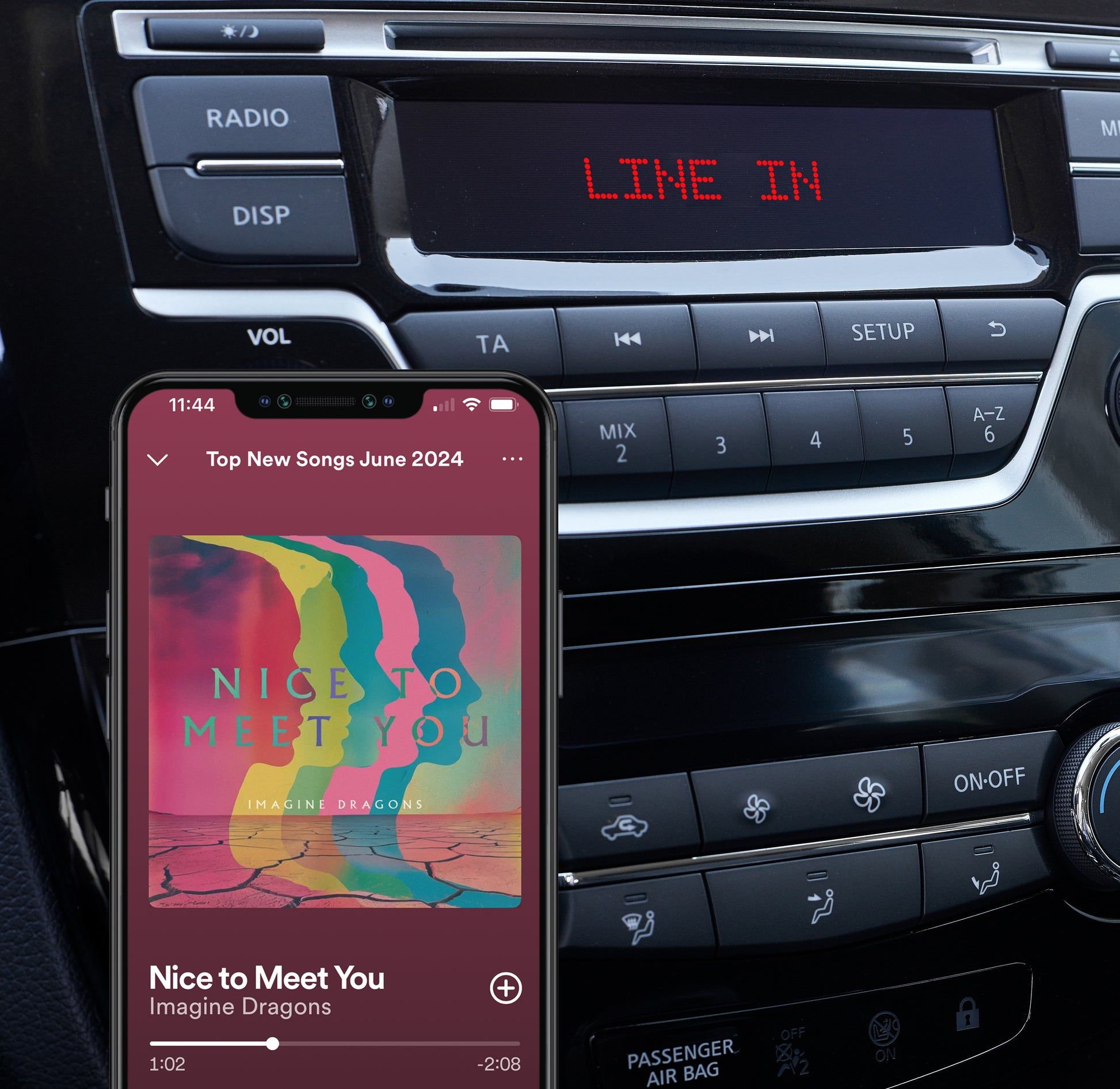 L'autoradio mostra 'LINE IN'. Un telefono mostra musica. Lo sfondo è l'interno dell'auto.