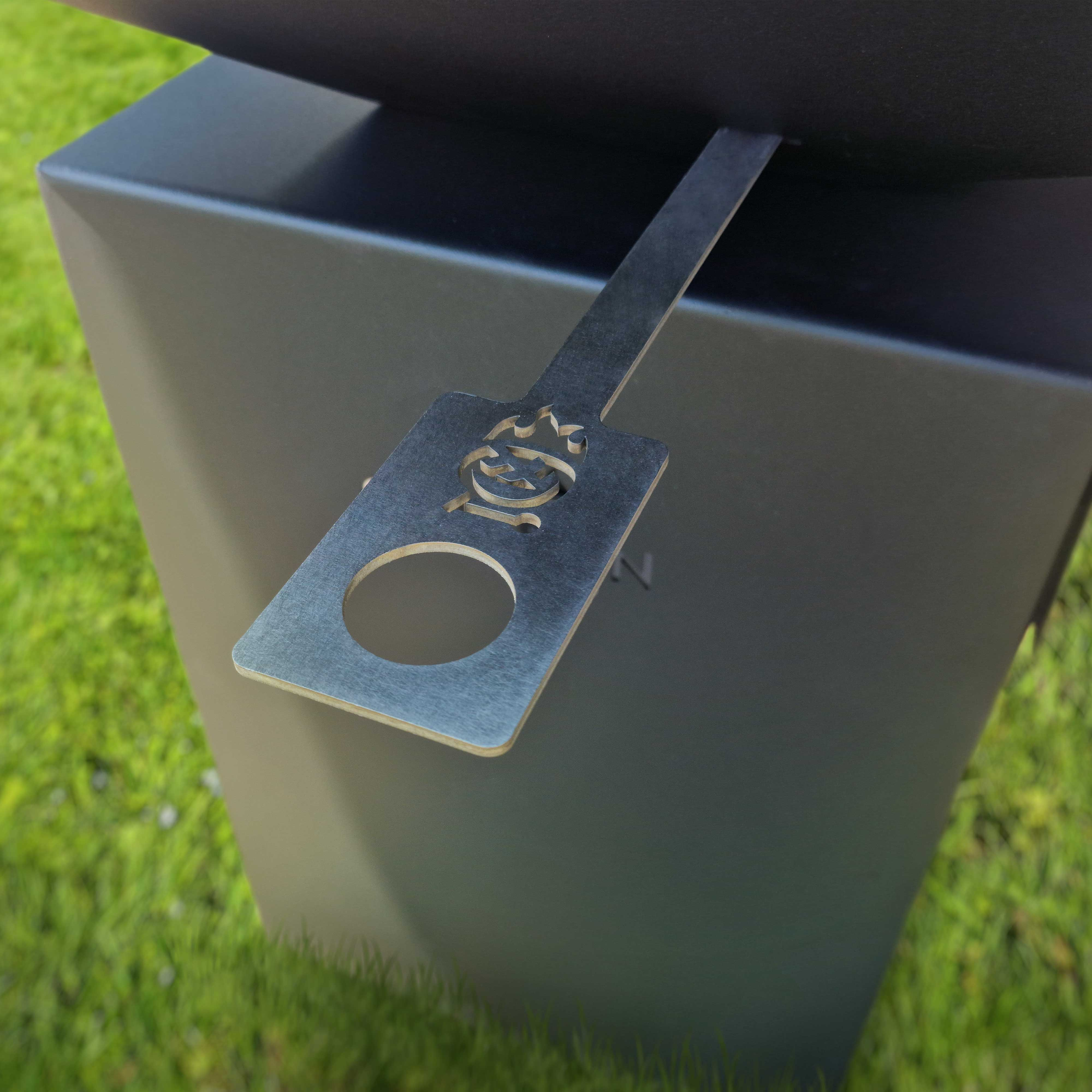 Metall-Grillwerkzeug auf schwarzem Ständer mit Logo.
