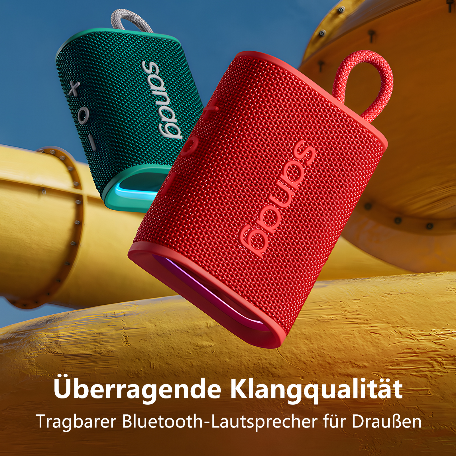 Zwei bunte tragbare Lautsprecher vor gelbem Rutschenhintergrund, mit deutschem Text.