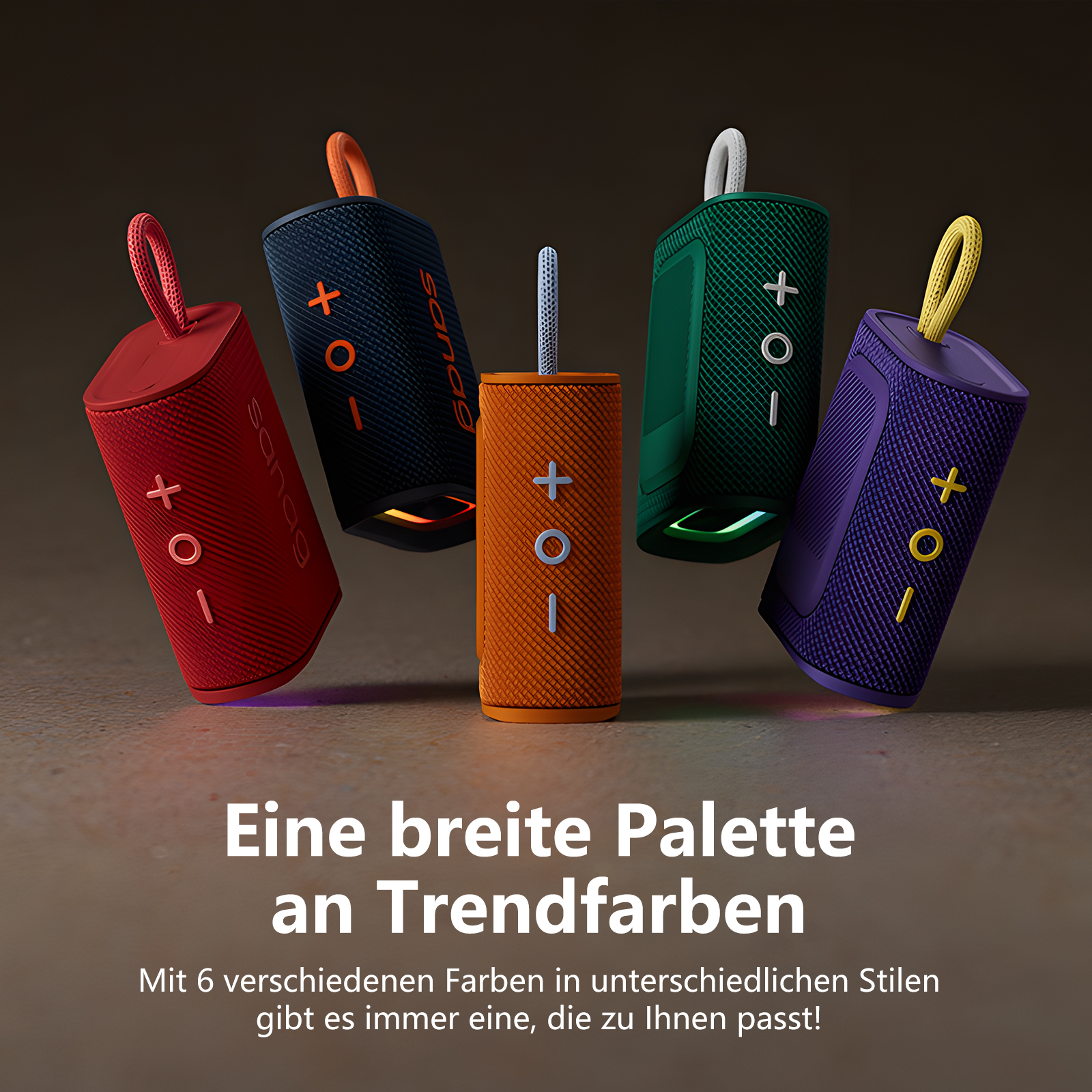 Fünf bunte tragbare Lautsprecher, rot, schwarz, orange, grün und lila, mit Text unten.