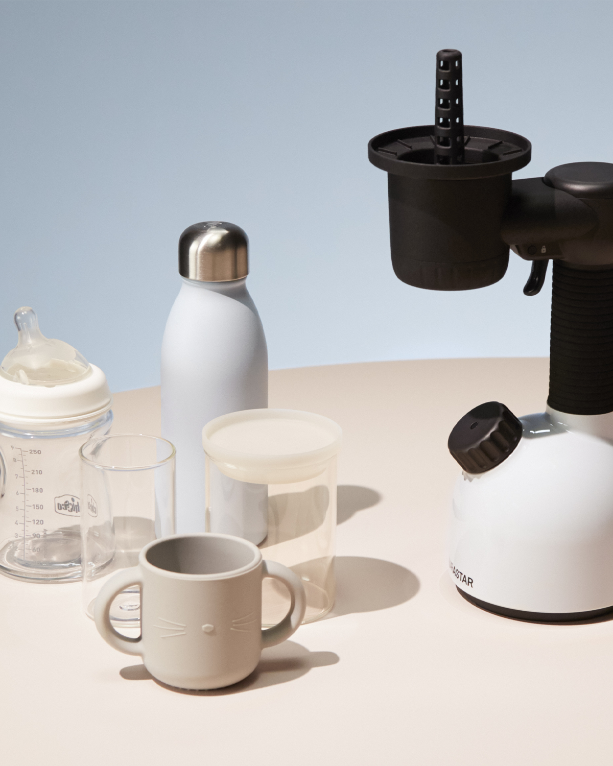 Eine Sammlung von Baby- und Kinderartikeln, darunter Flaschen, eine Wasserflasche und ein Dampfsterilisator.