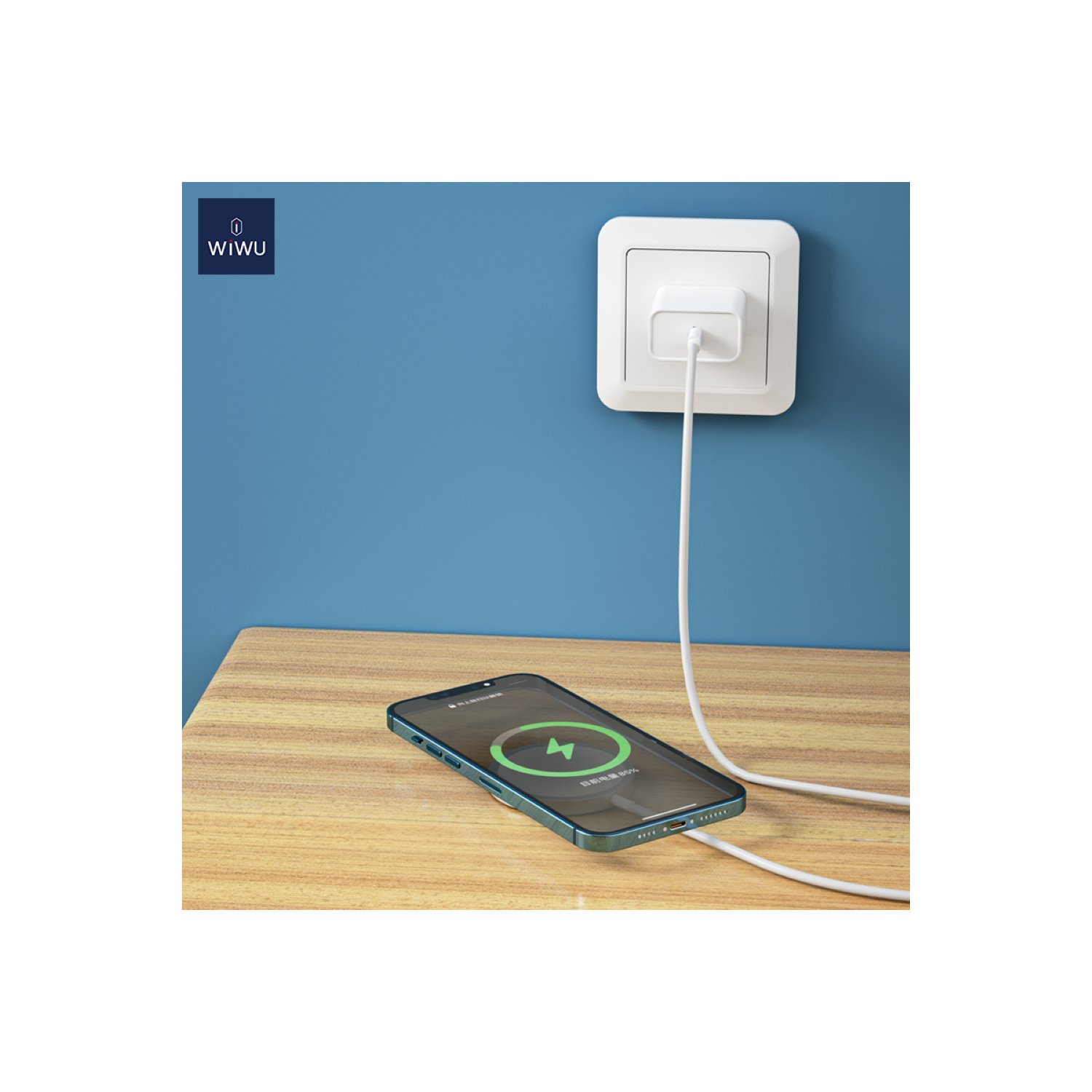 Smartphone wird geladen, Kabel und Ladegerät in der Steckdose. Holz und blaue Wand.