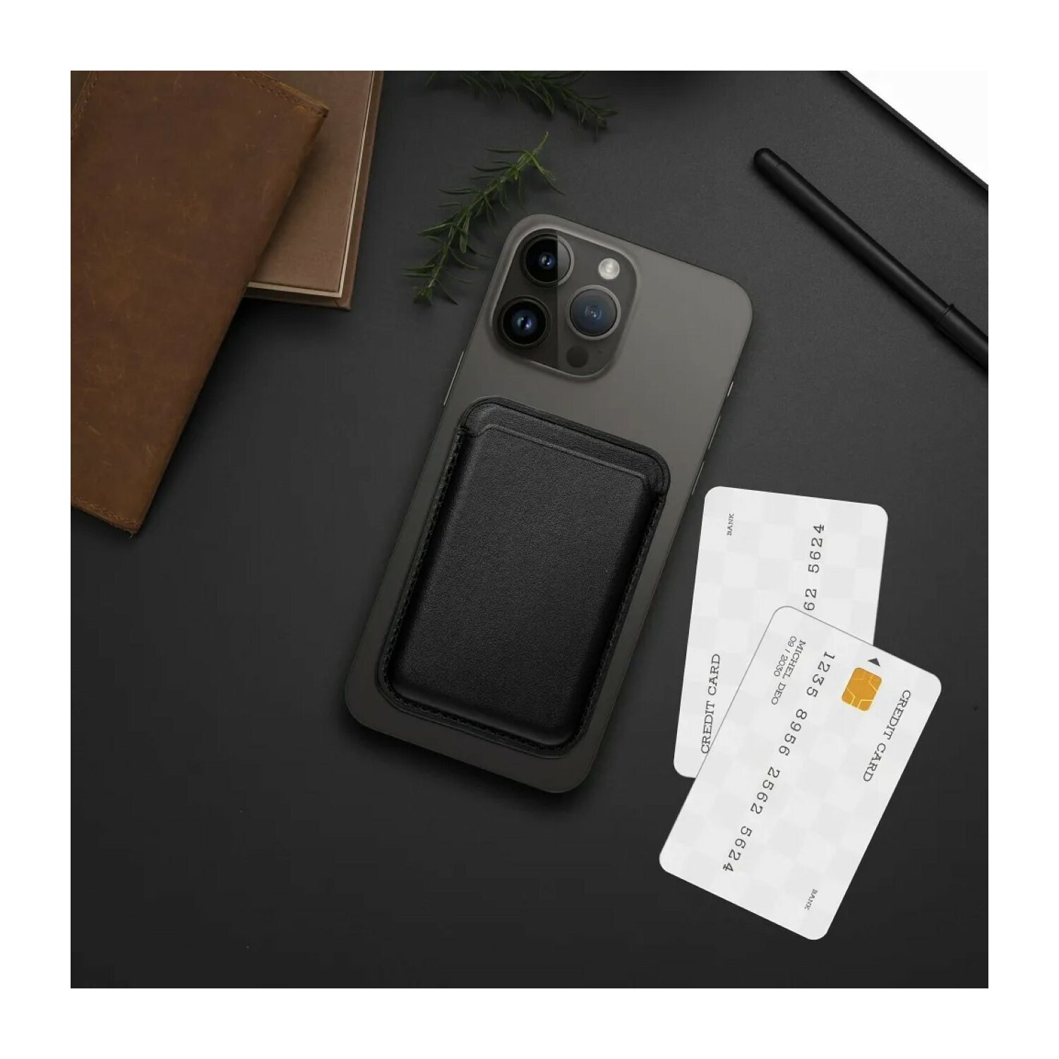Un telefono nero con un porta carte in pelle nera e due carte di credito bianche su una superficie scura.