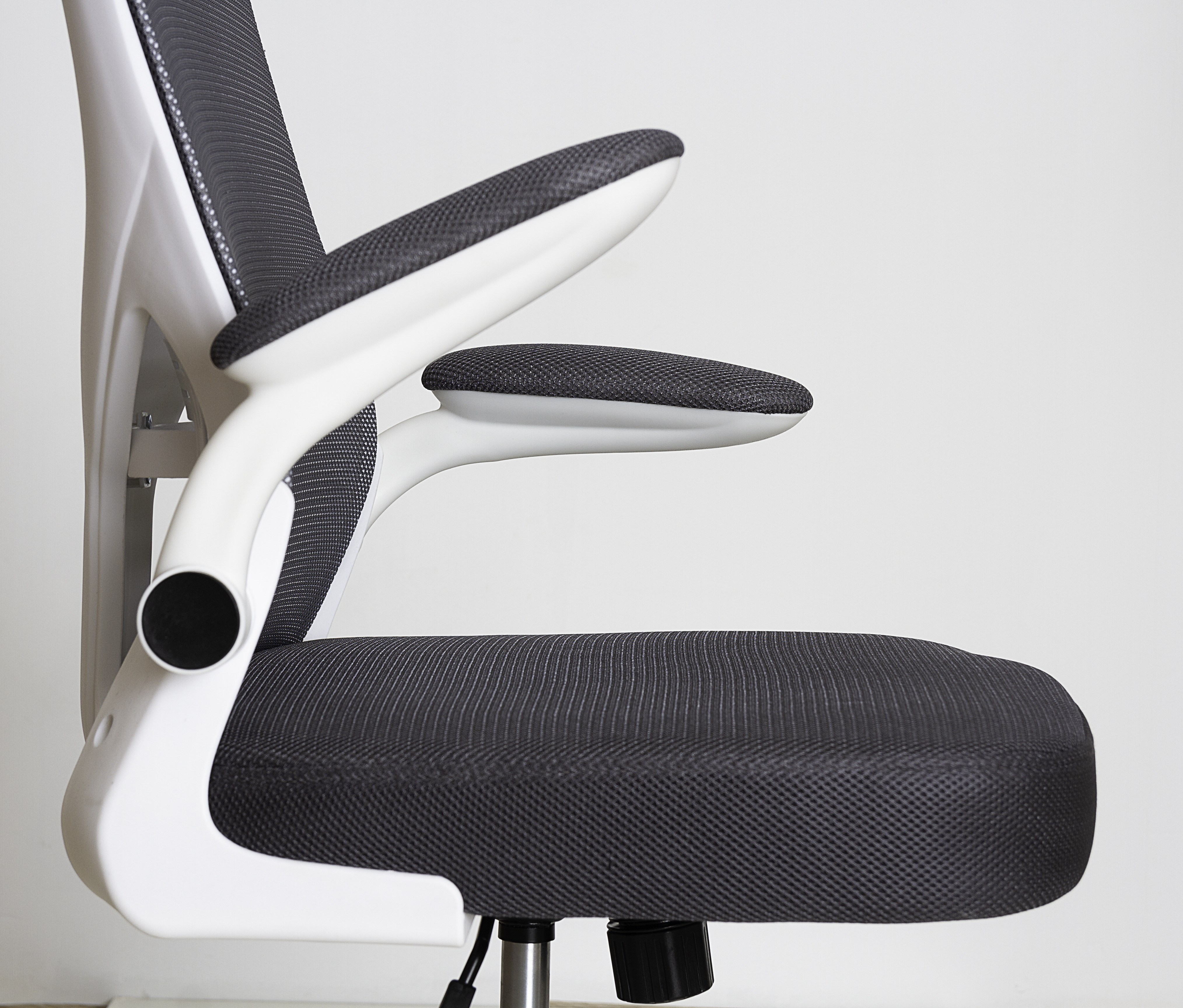 Primer plano de una silla de oficina blanca y gris con reposabrazos.