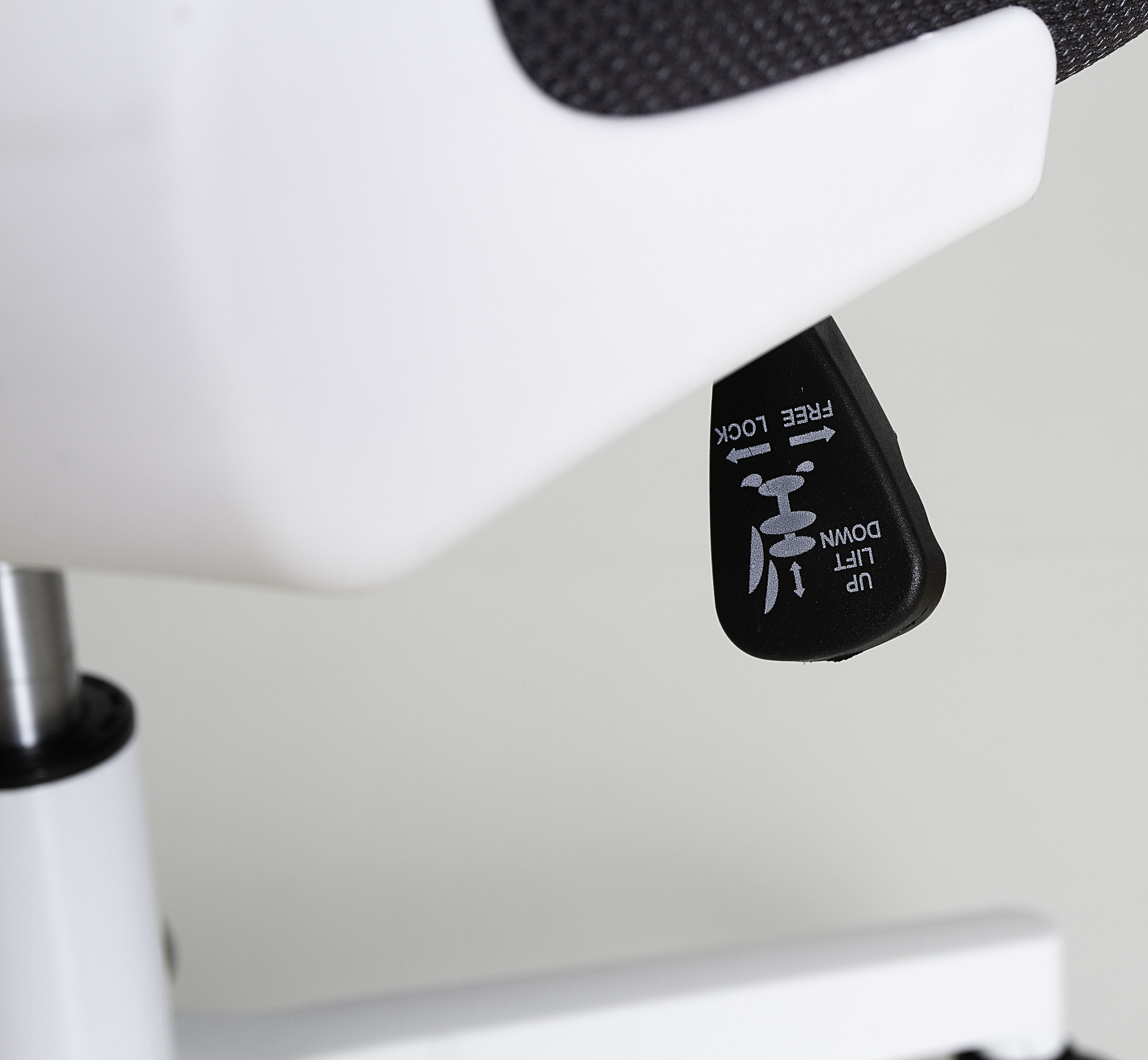 Primer plano de la palanca de control de una silla de oficina. Negro con texto e iconos blancos.